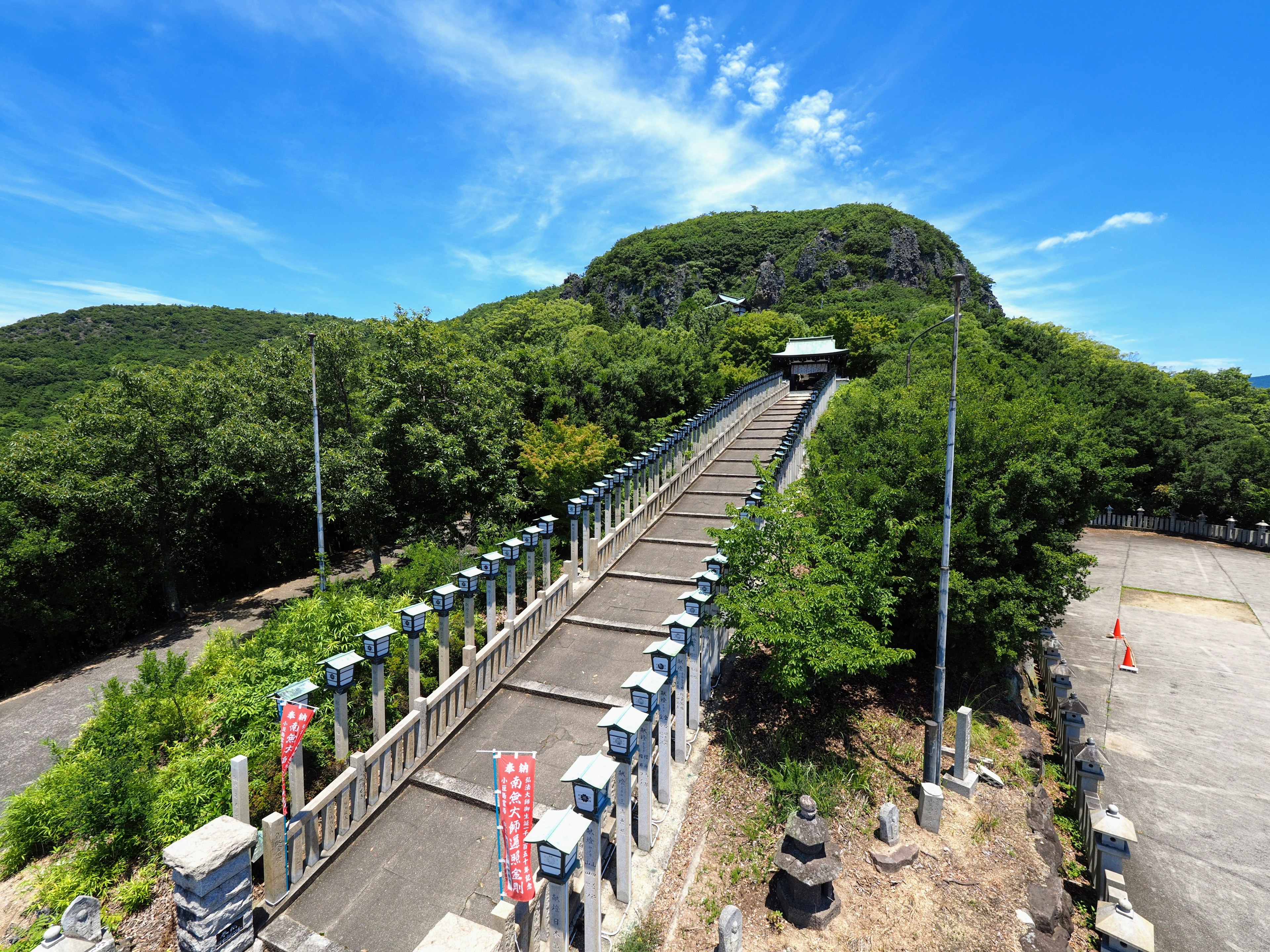 Un long escalier menant à une colline verte sous un ciel bleu