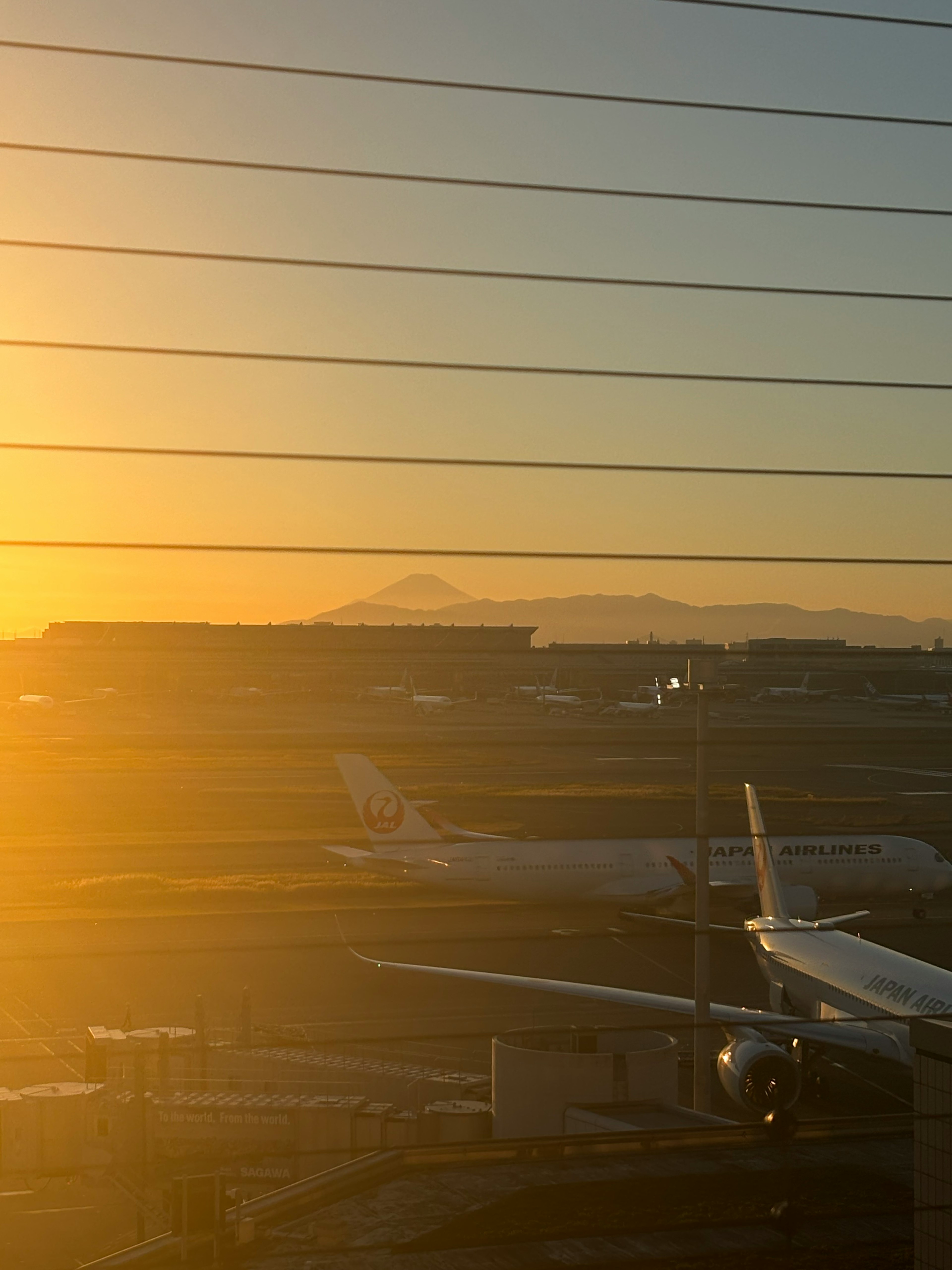 해질녘의 공항 풍경 비행기 뒤에 보이는 먼 산