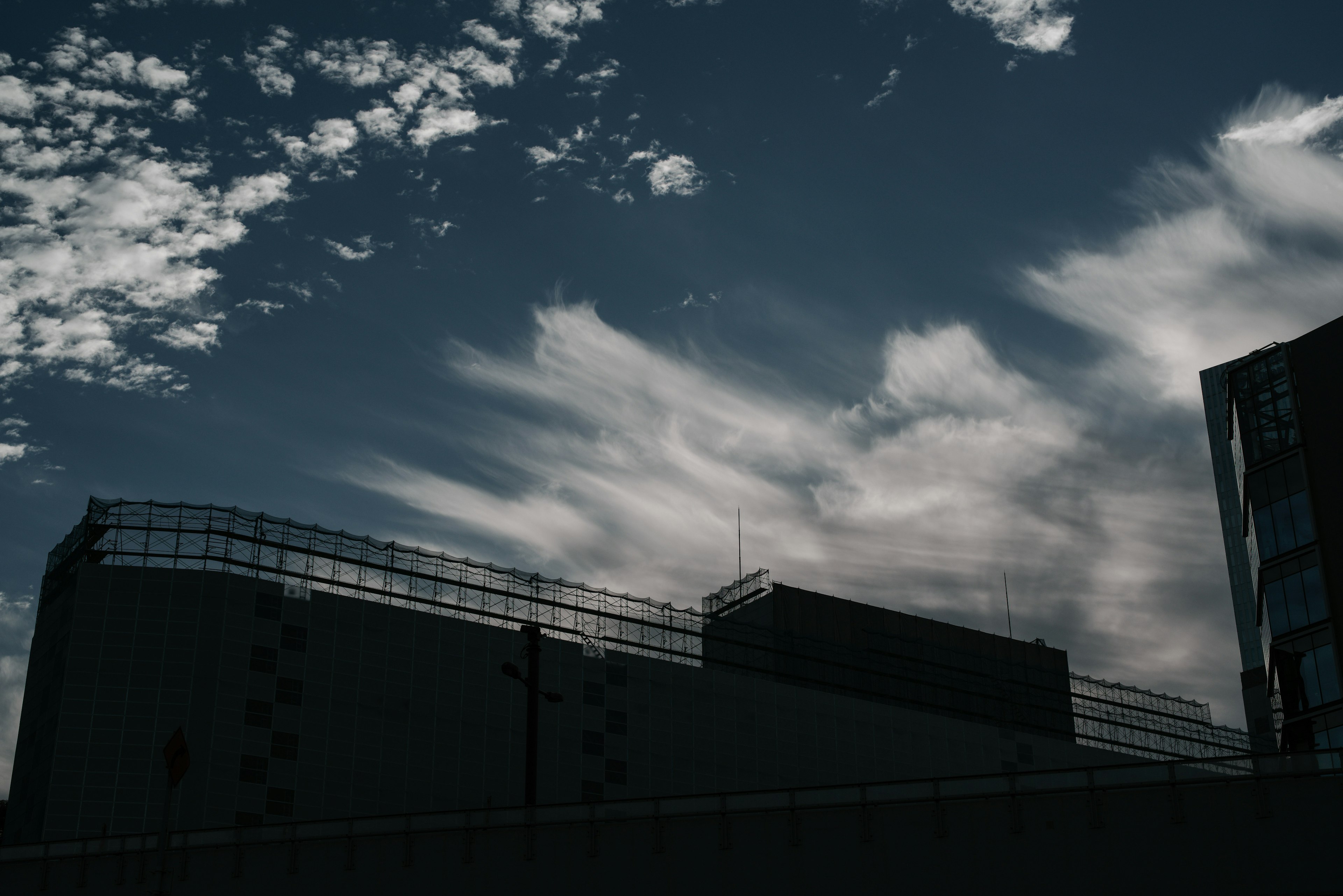 Silhouette of buildings against a blue sky with scattered clouds