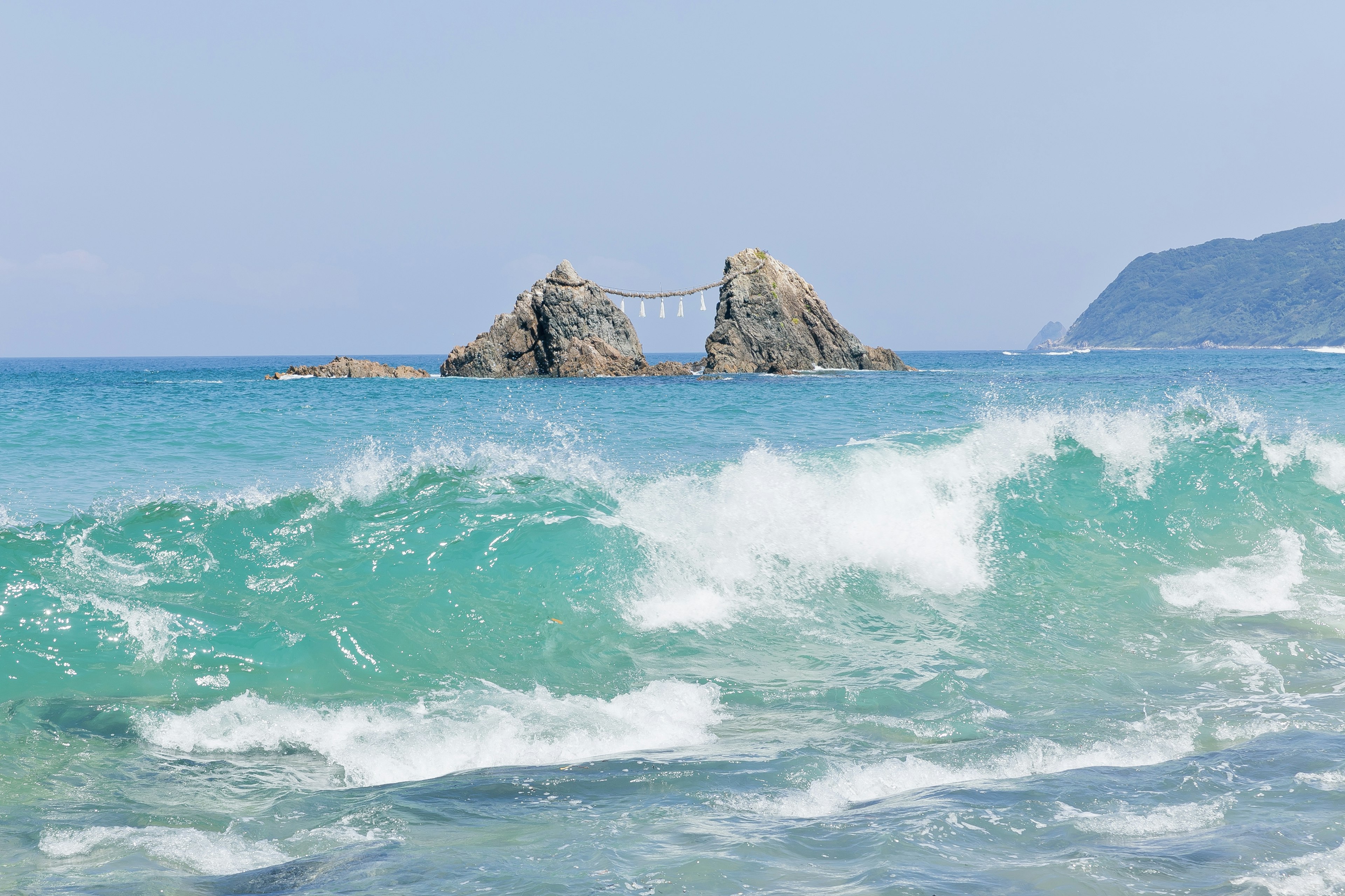 海浪拍打著岩石形成的景觀，海水呈現出藍綠色