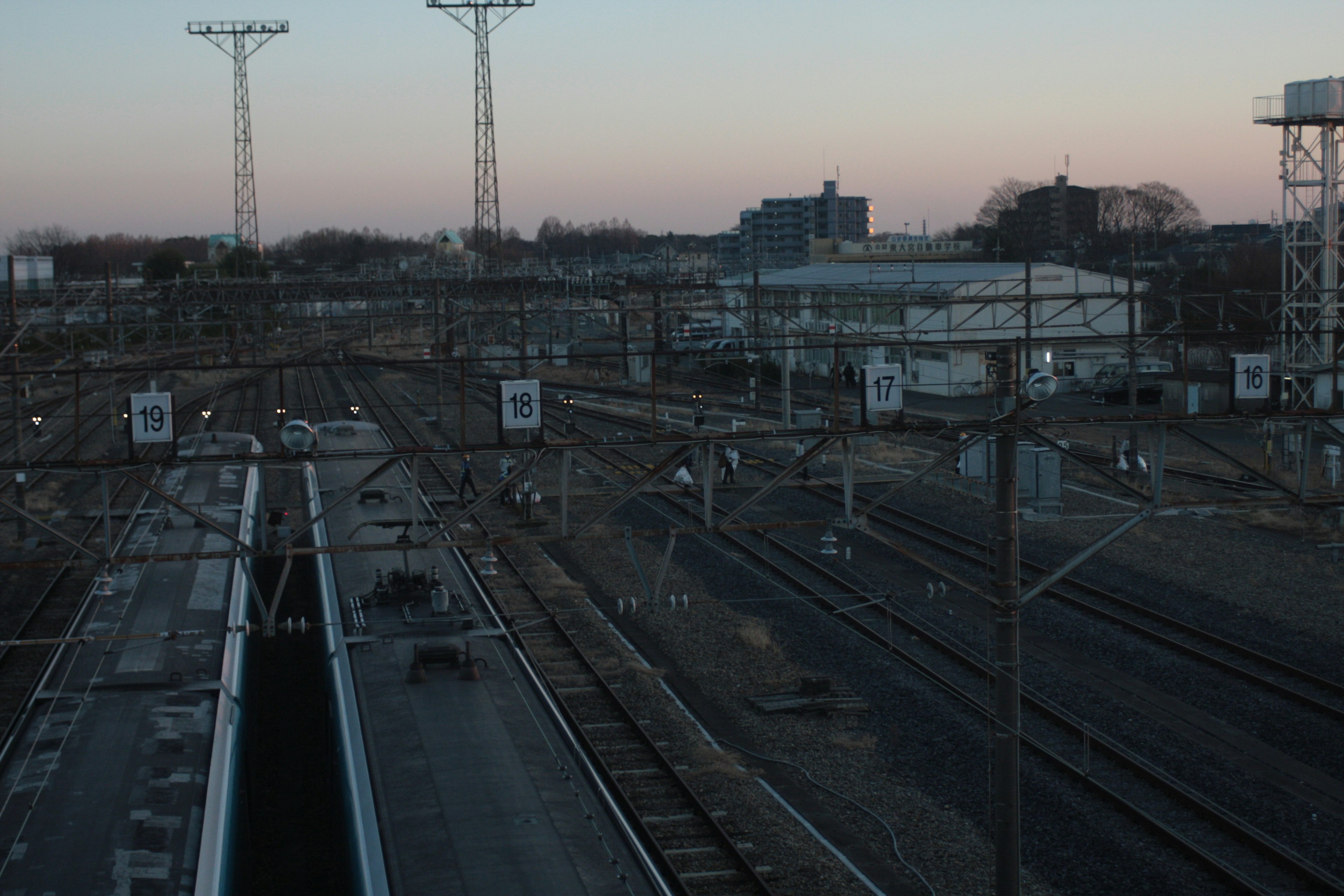 Dusk railway landscape featuring tracks and signal lights