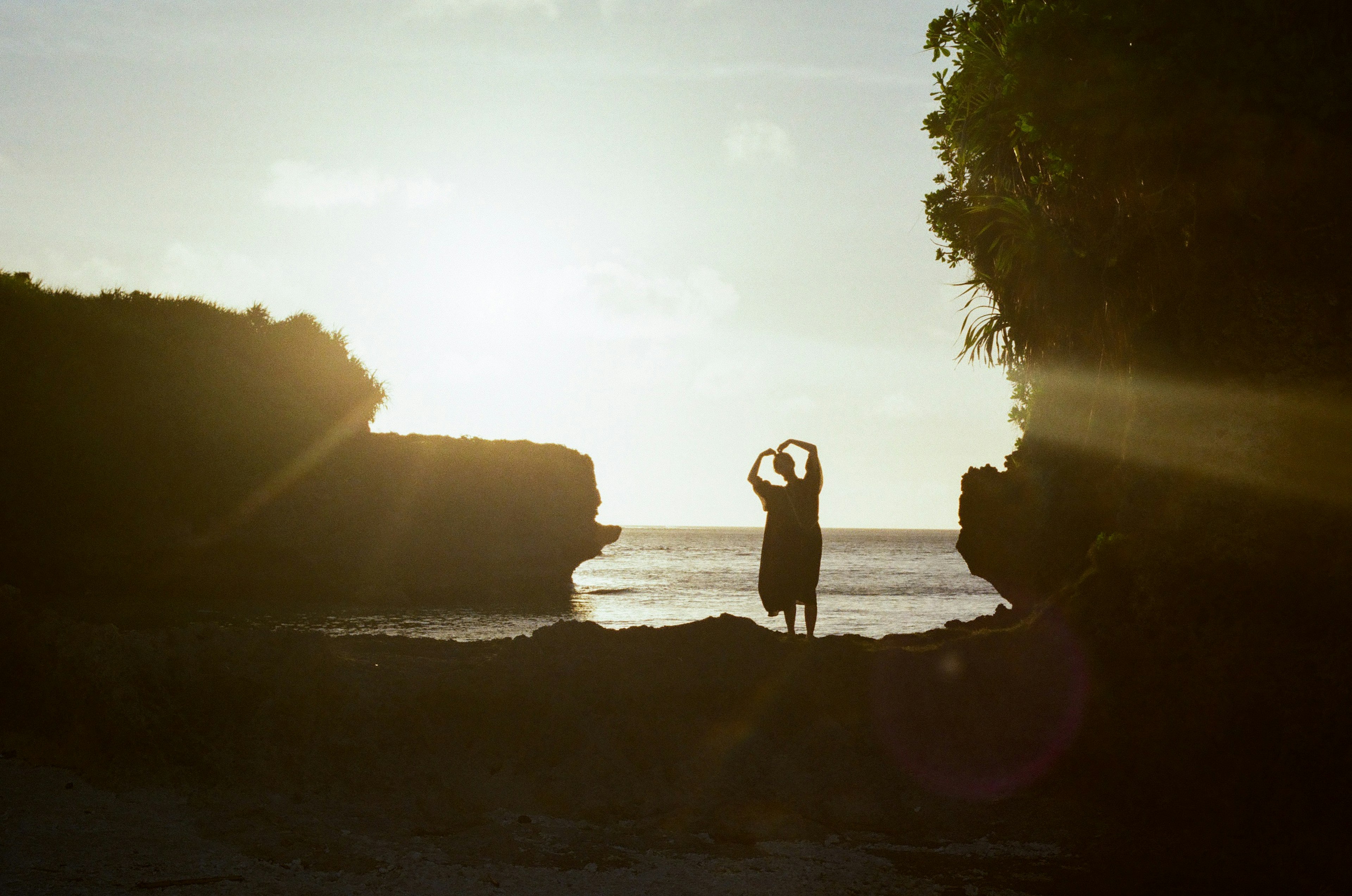 Una persona posando en una playa al atardecer