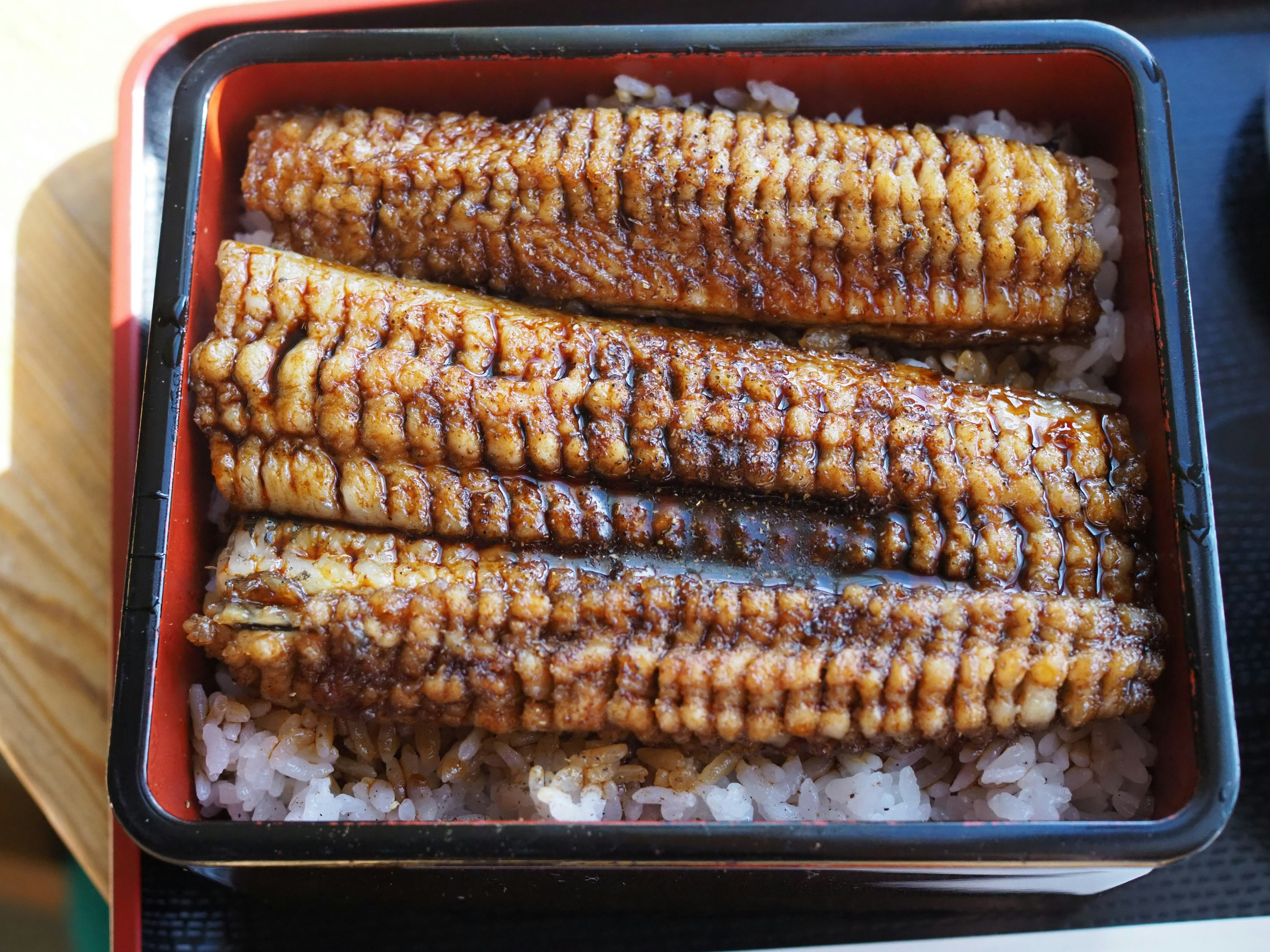 Ikan belut bakar di atas nasi dalam kotak bento