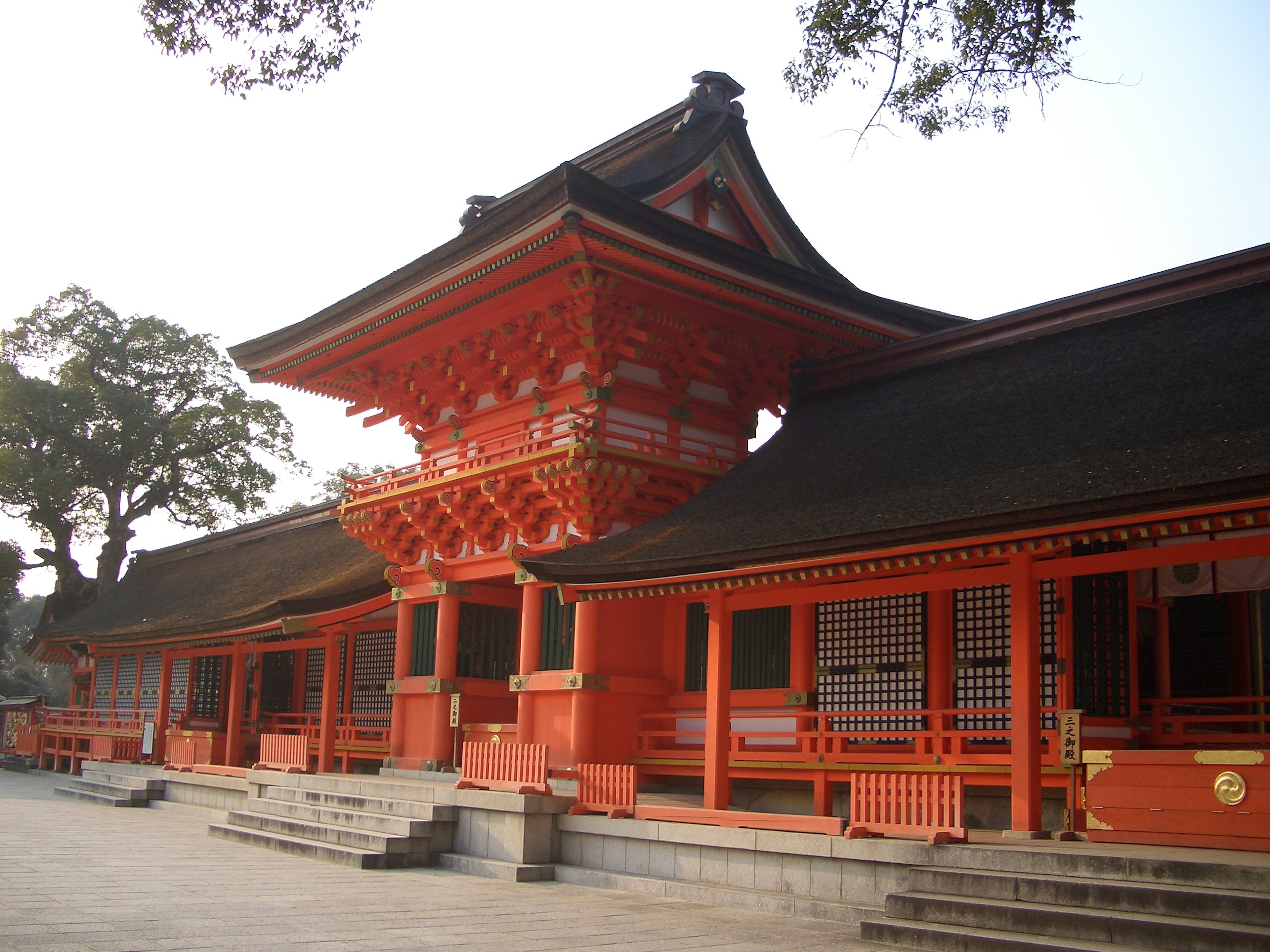 Exterior of a shrine featuring red buildings and black roofs