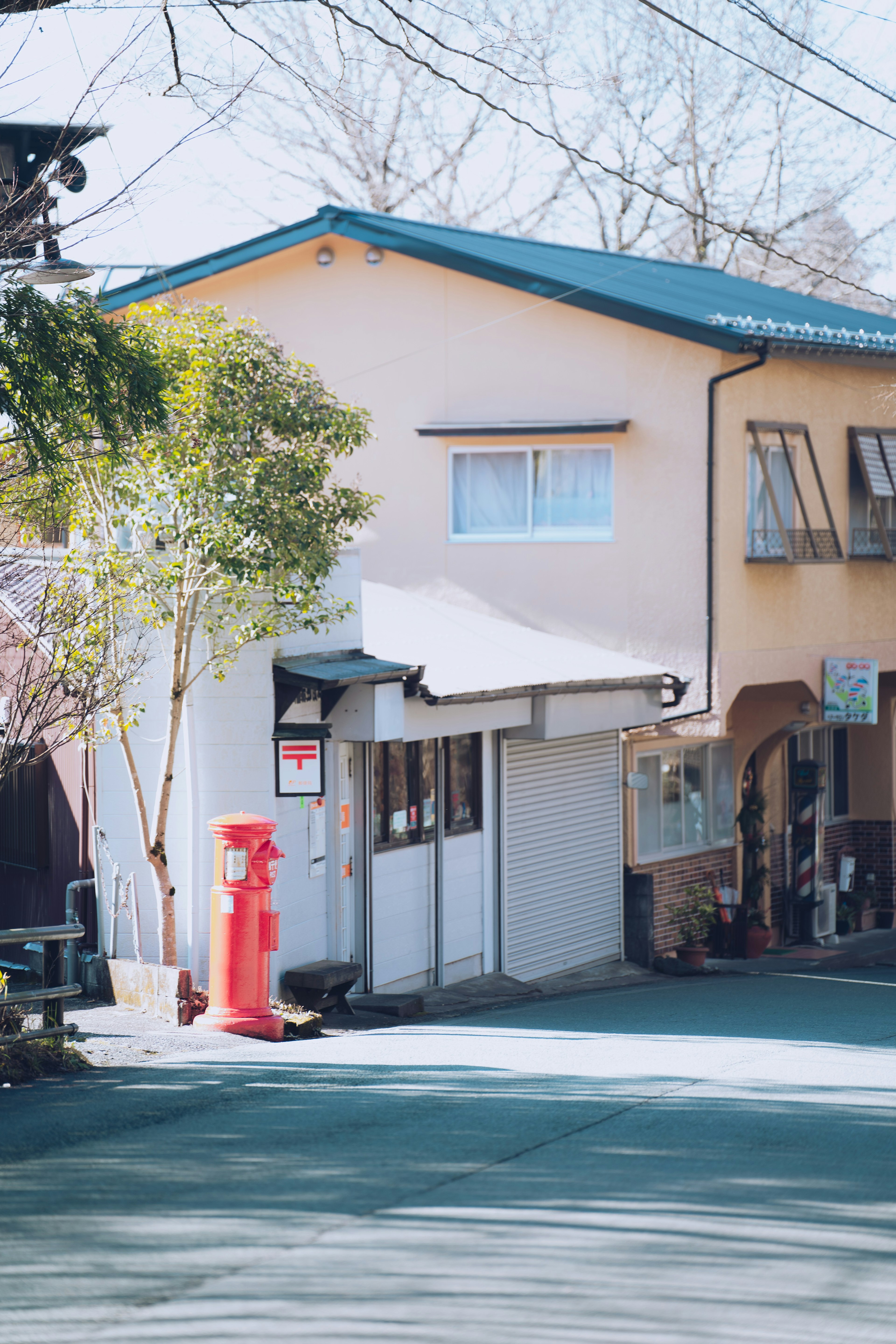 Maison japonaise à un coin de rue tranquille avec une boîte aux lettres rouge