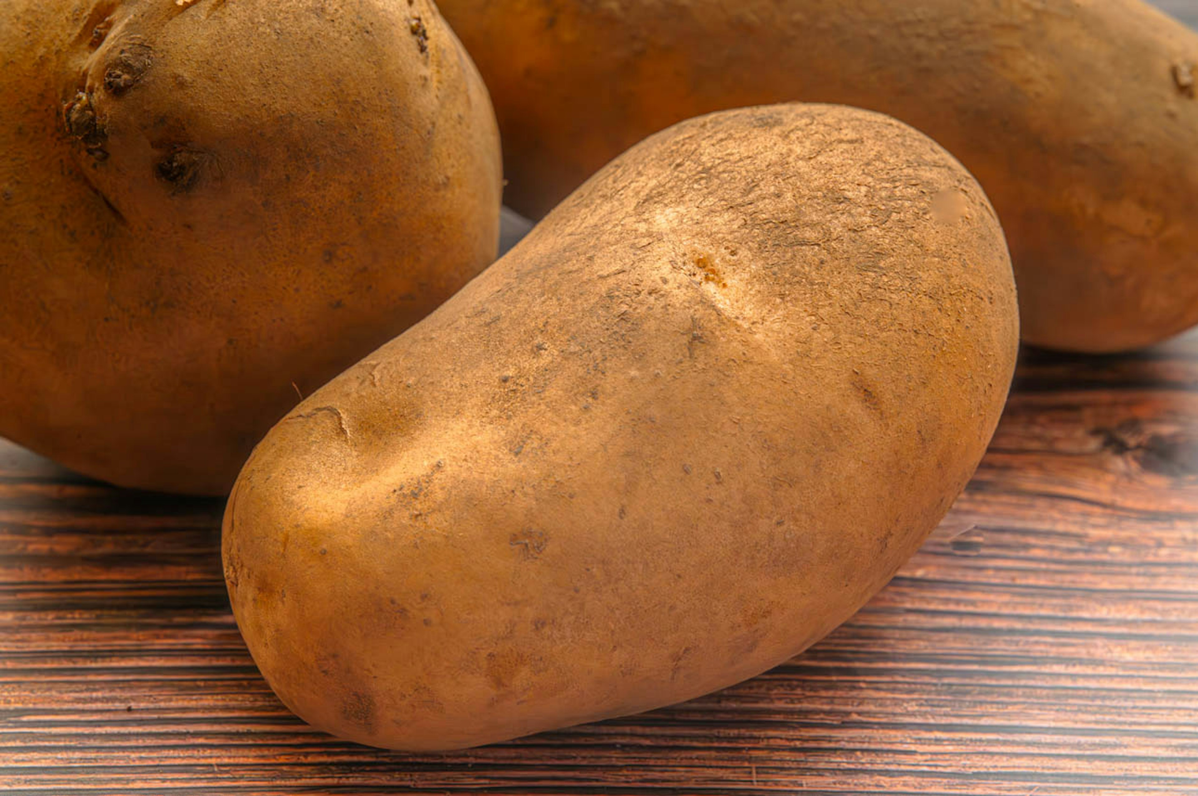 Brown potatoes placed on a wooden table