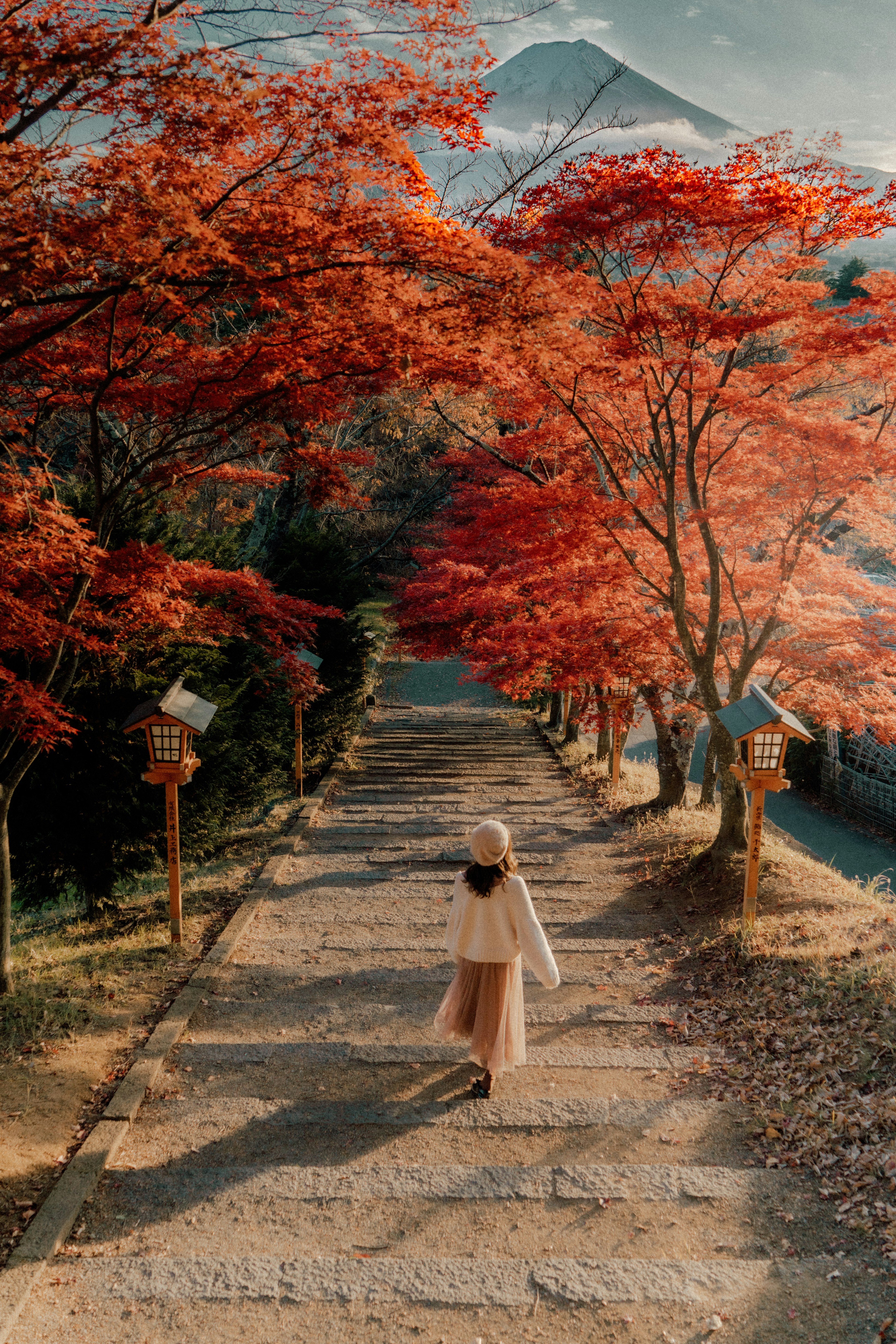 秋の紅葉の中を歩く女性と富士山の背景