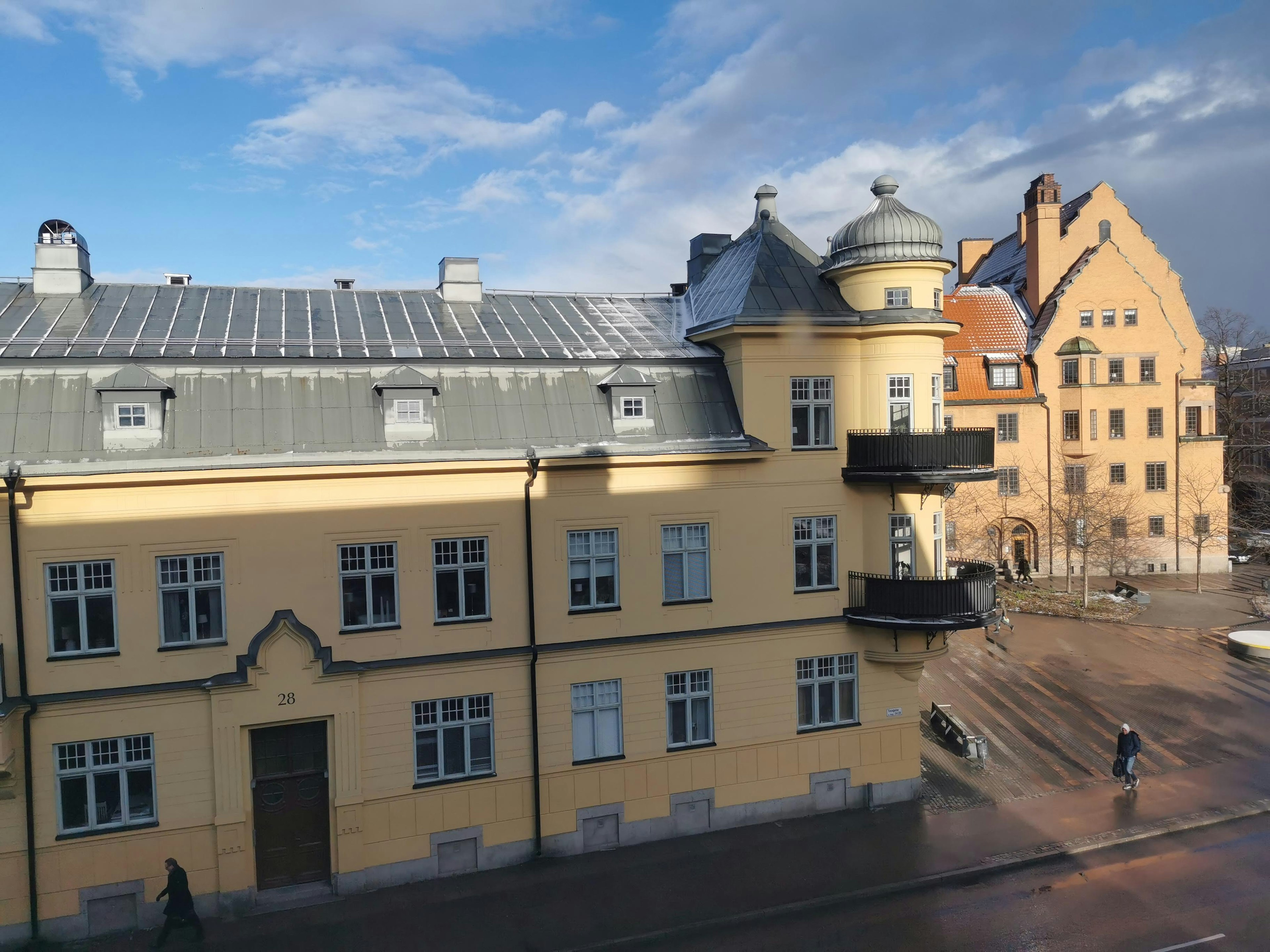 Historisches Gebäude mit leuchtend gelber Fassade und modernem Dachdesign