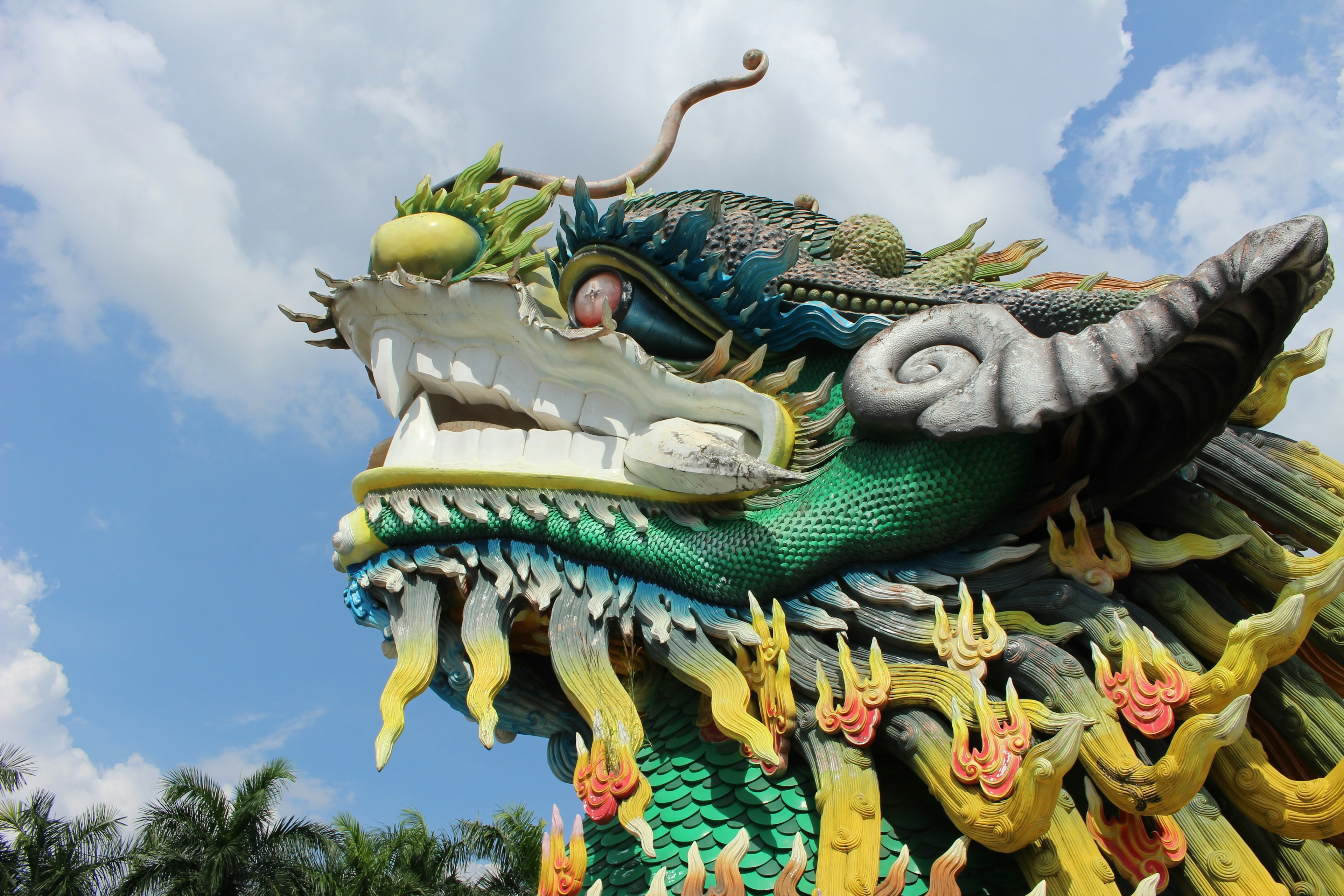 Sculpture de dragon vibrante se dressant contre un ciel bleu