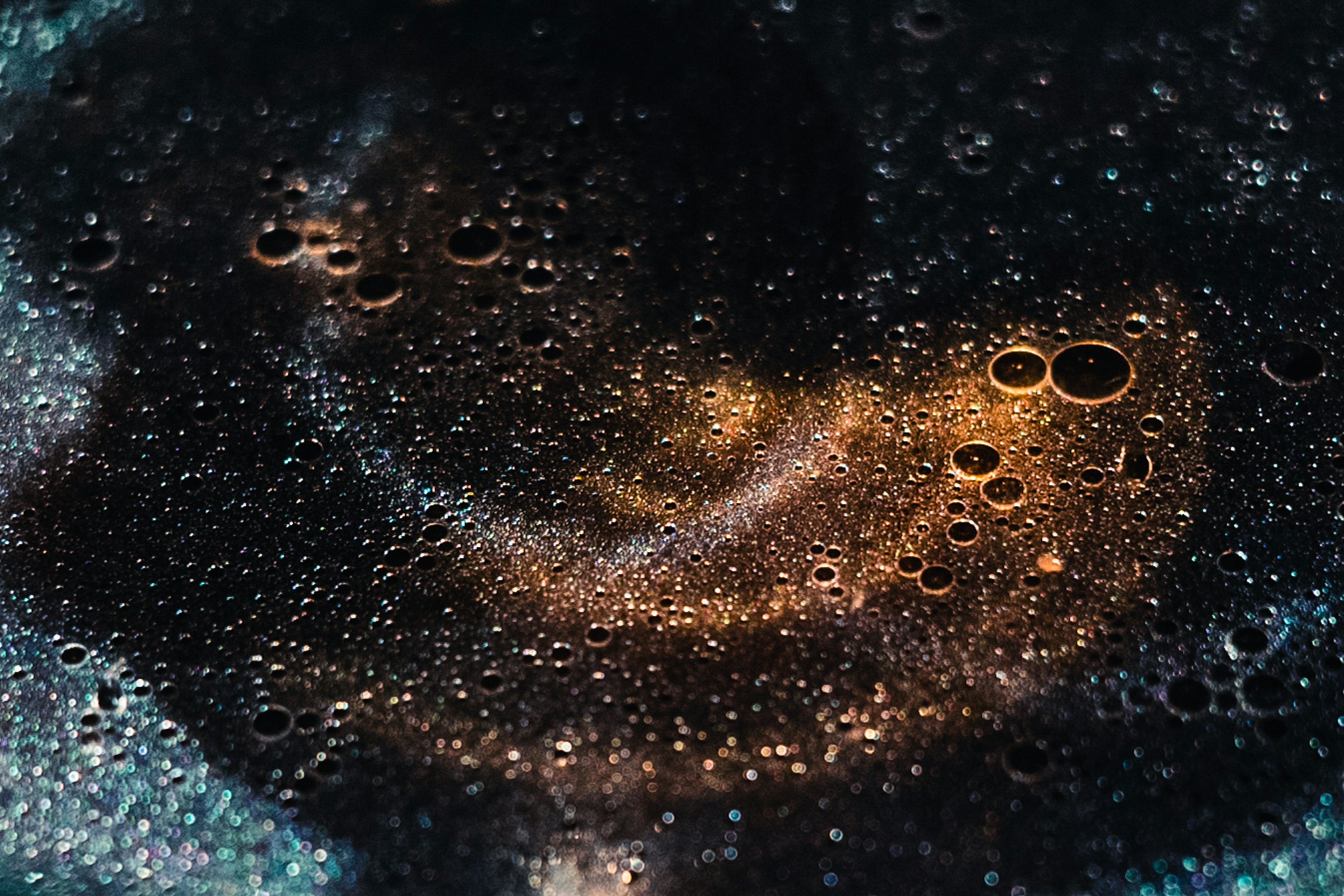 Golden bubbles and silver particles floating on a black background