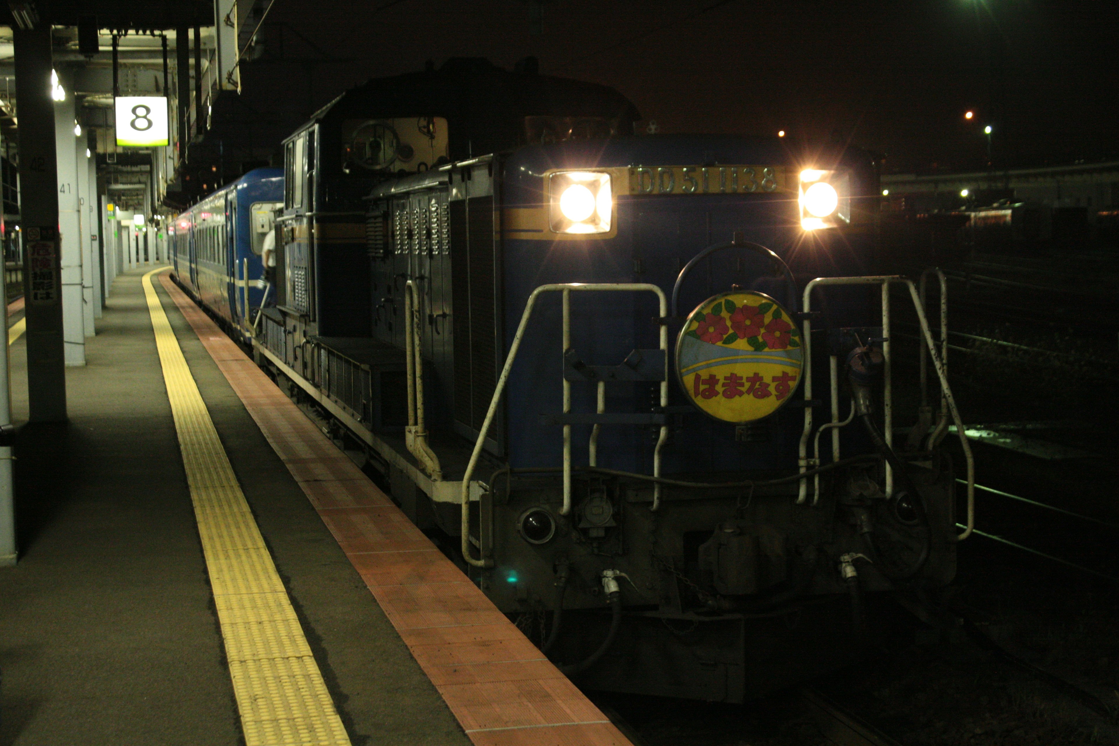 Locomotive bleue dans une gare de nuit