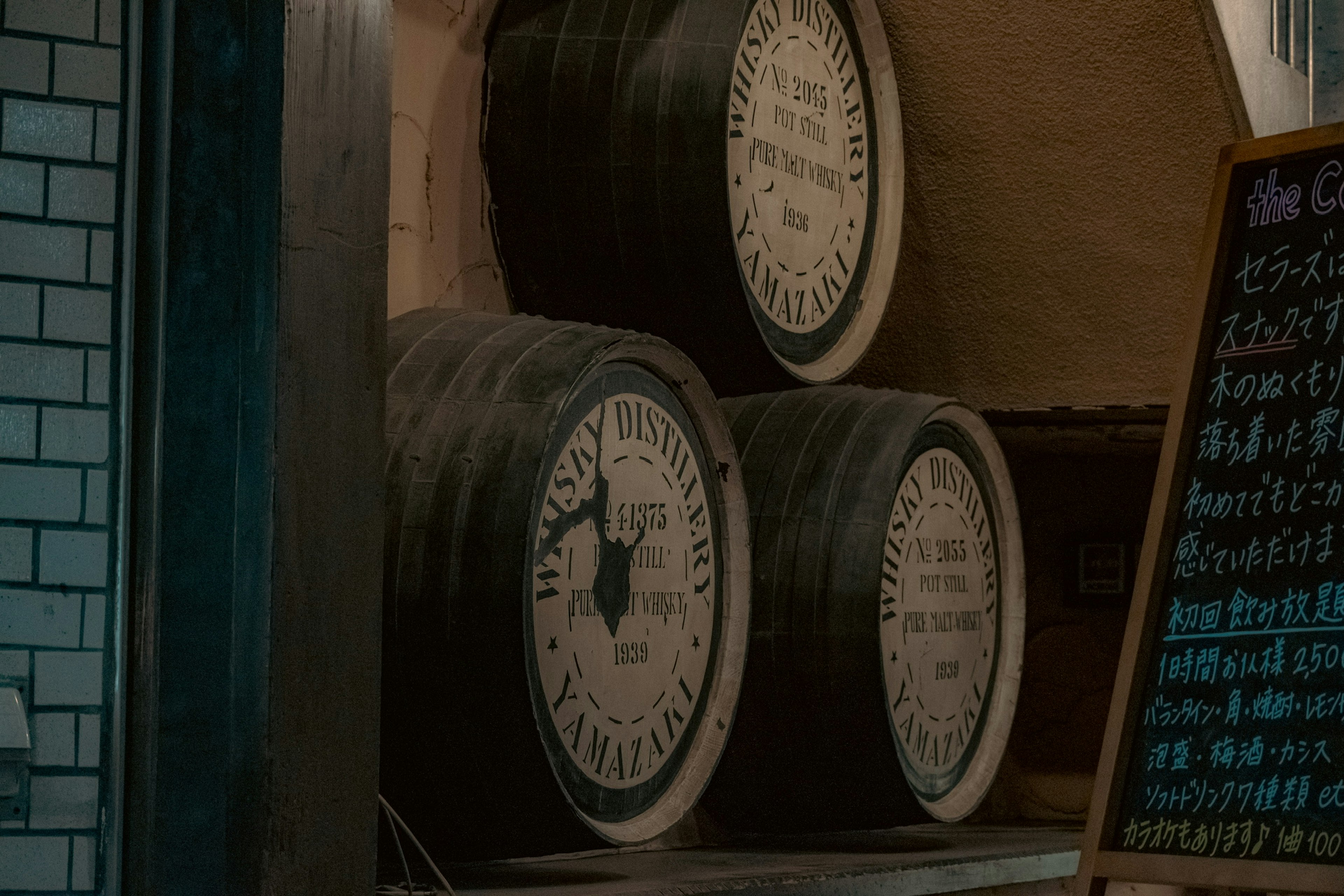 Wooden barrels stacked in a sake brewery interior