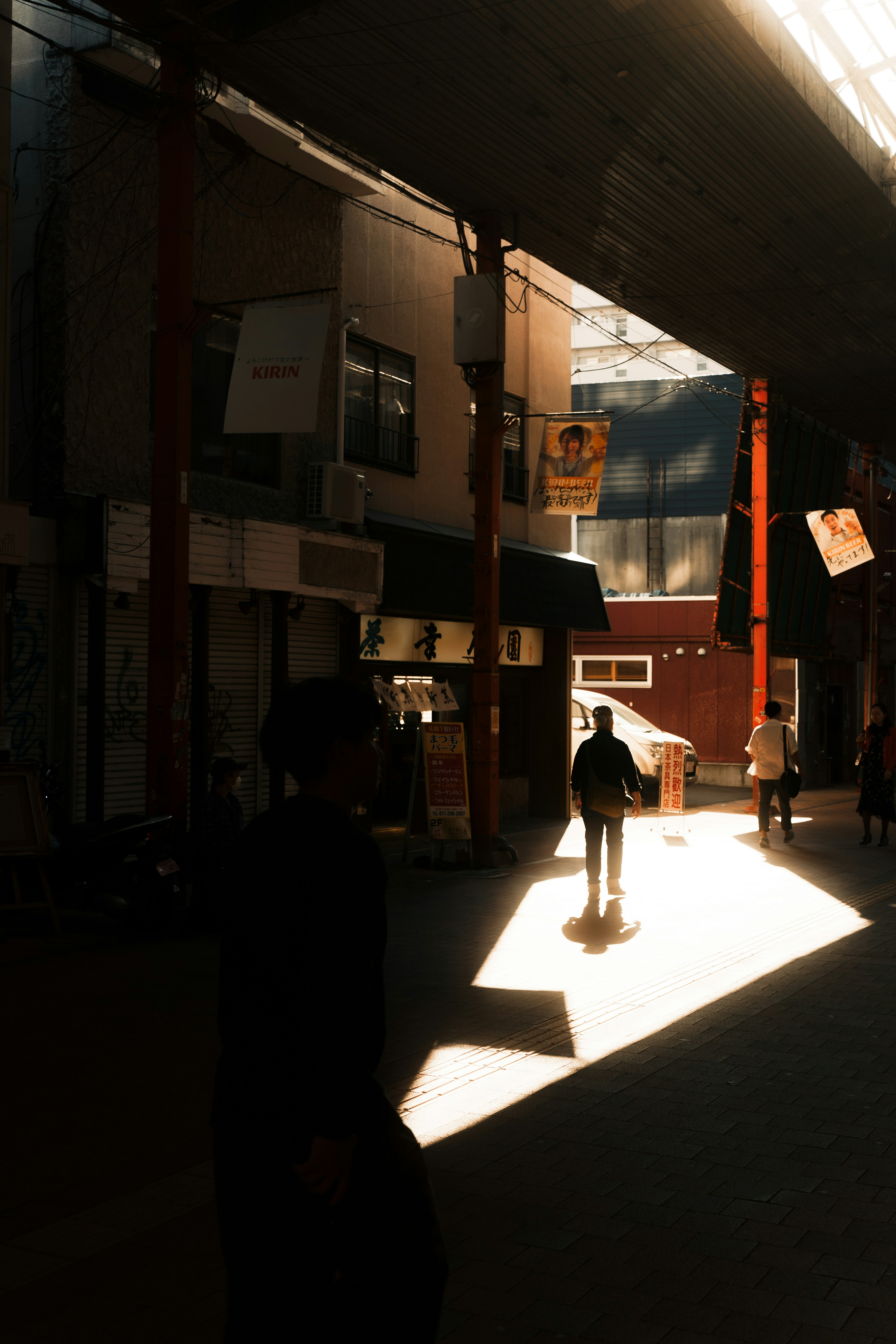 Personas caminando en un pasillo de una zona comercial con luz brillante