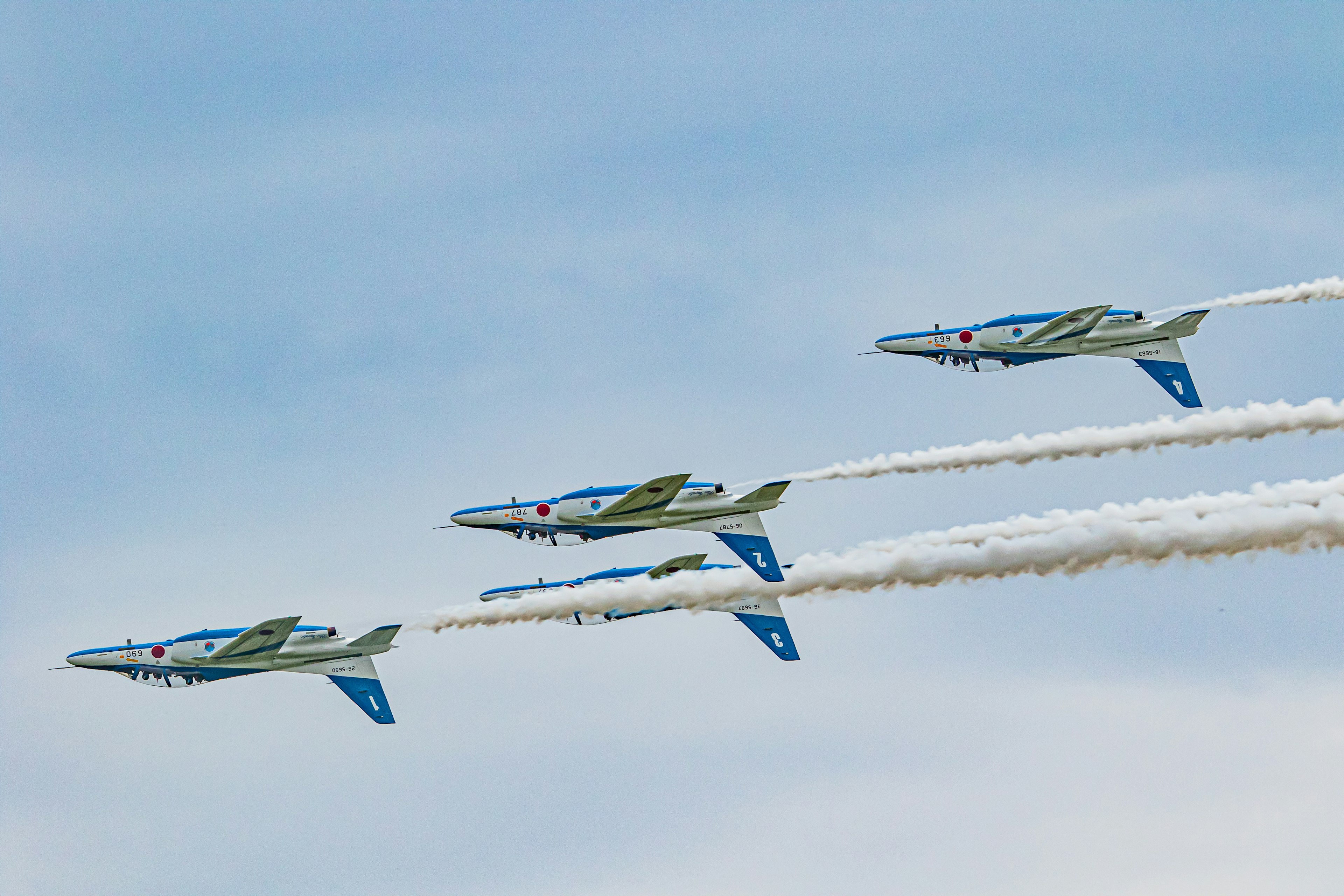 Vuelo en formación dinámica de tres aviones contra un cielo azul