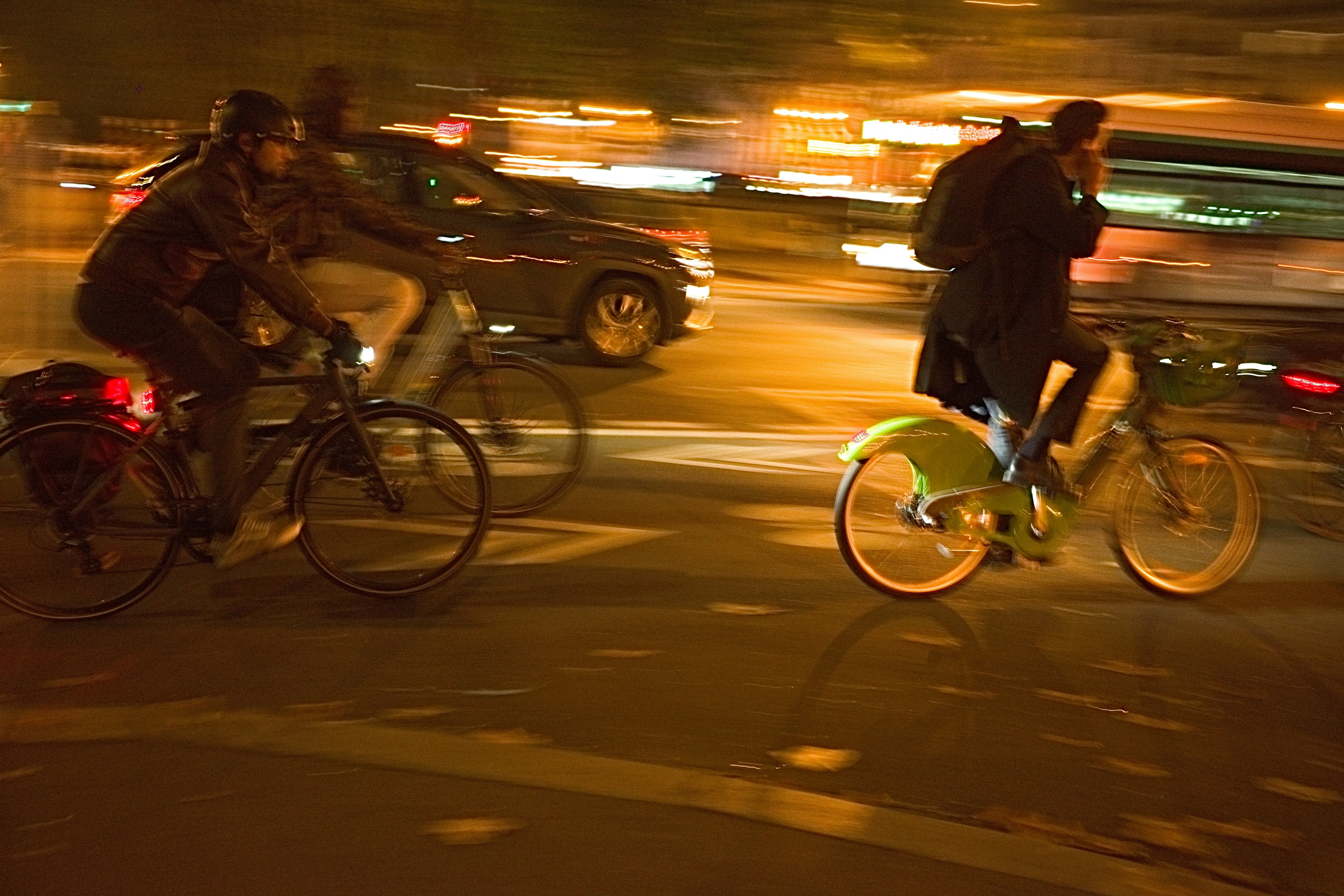 Ciclistas montando en una ciudad bulliciosa de noche