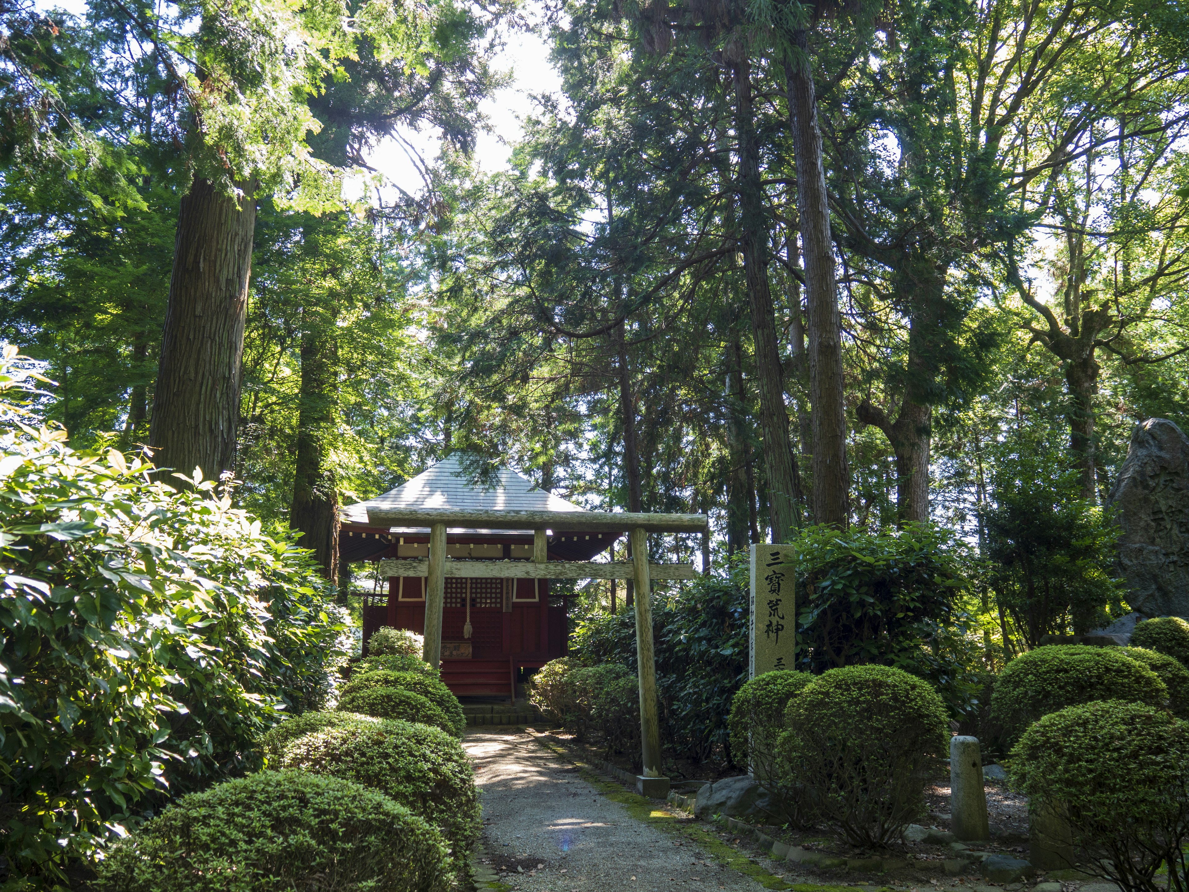 Entrance to a red building surrounded by lush greenery