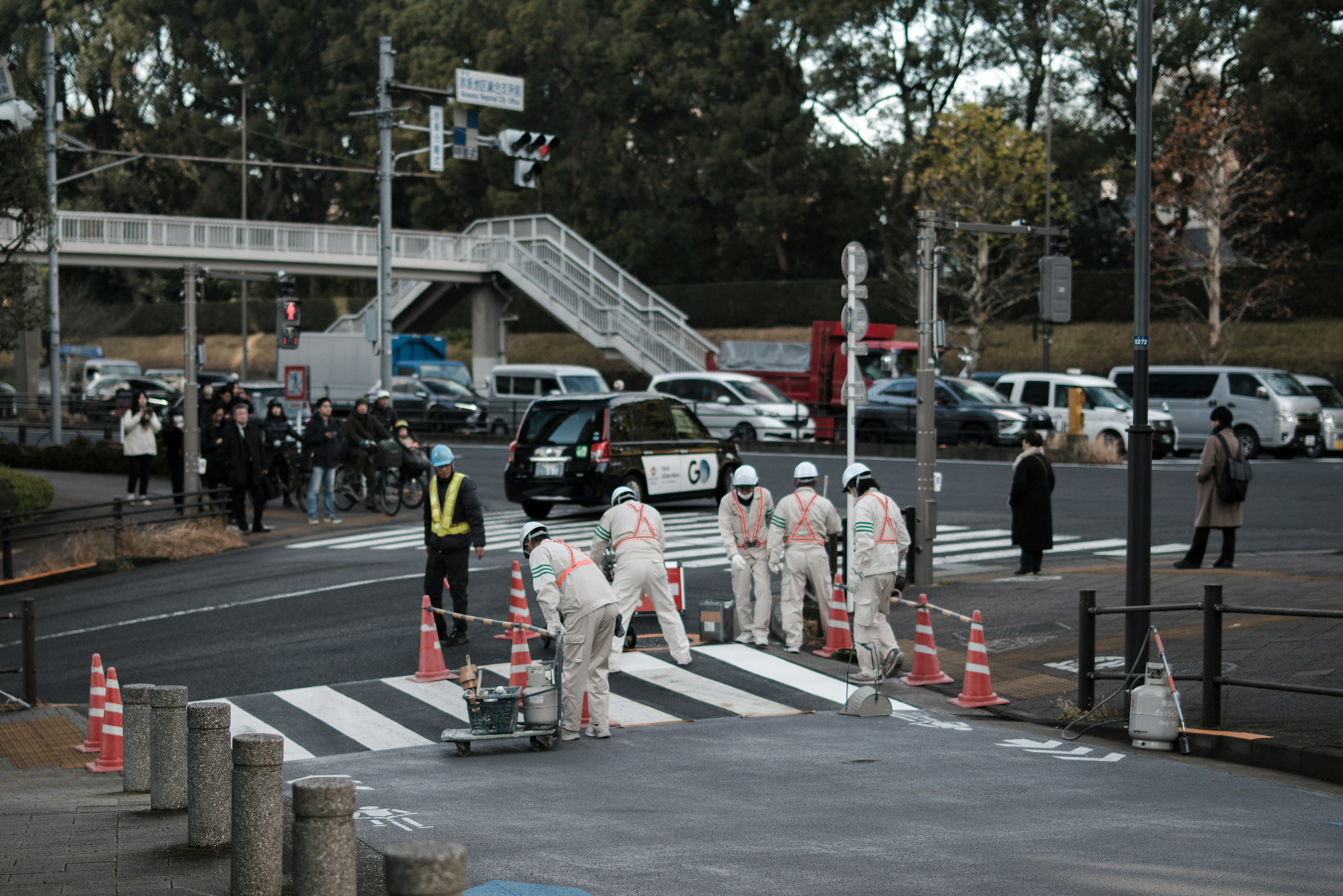 横断歩道で作業する作業員と交通の様子