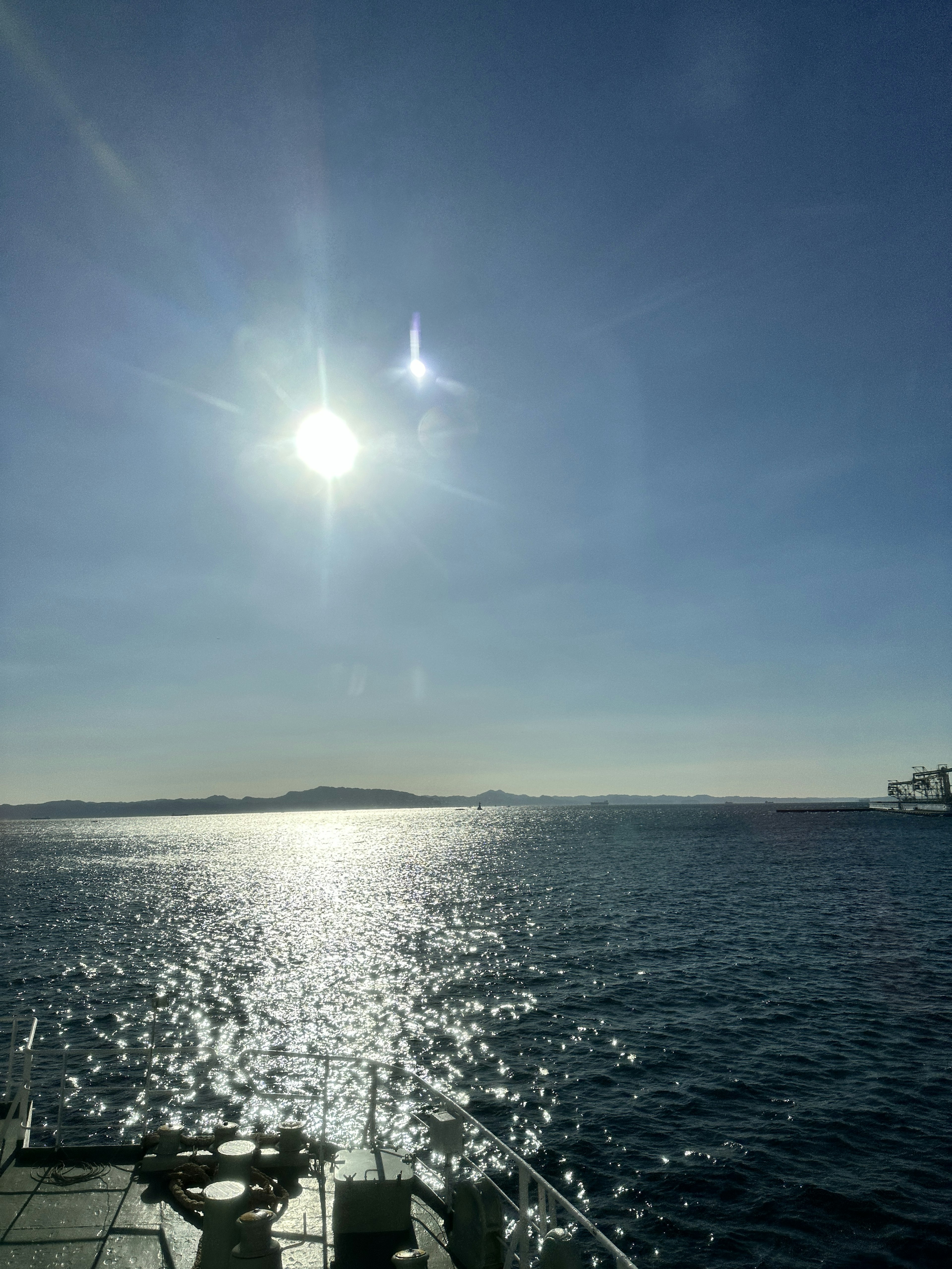 Pemandangan indah lautan biru yang memantulkan sinar matahari dengan langit cerah