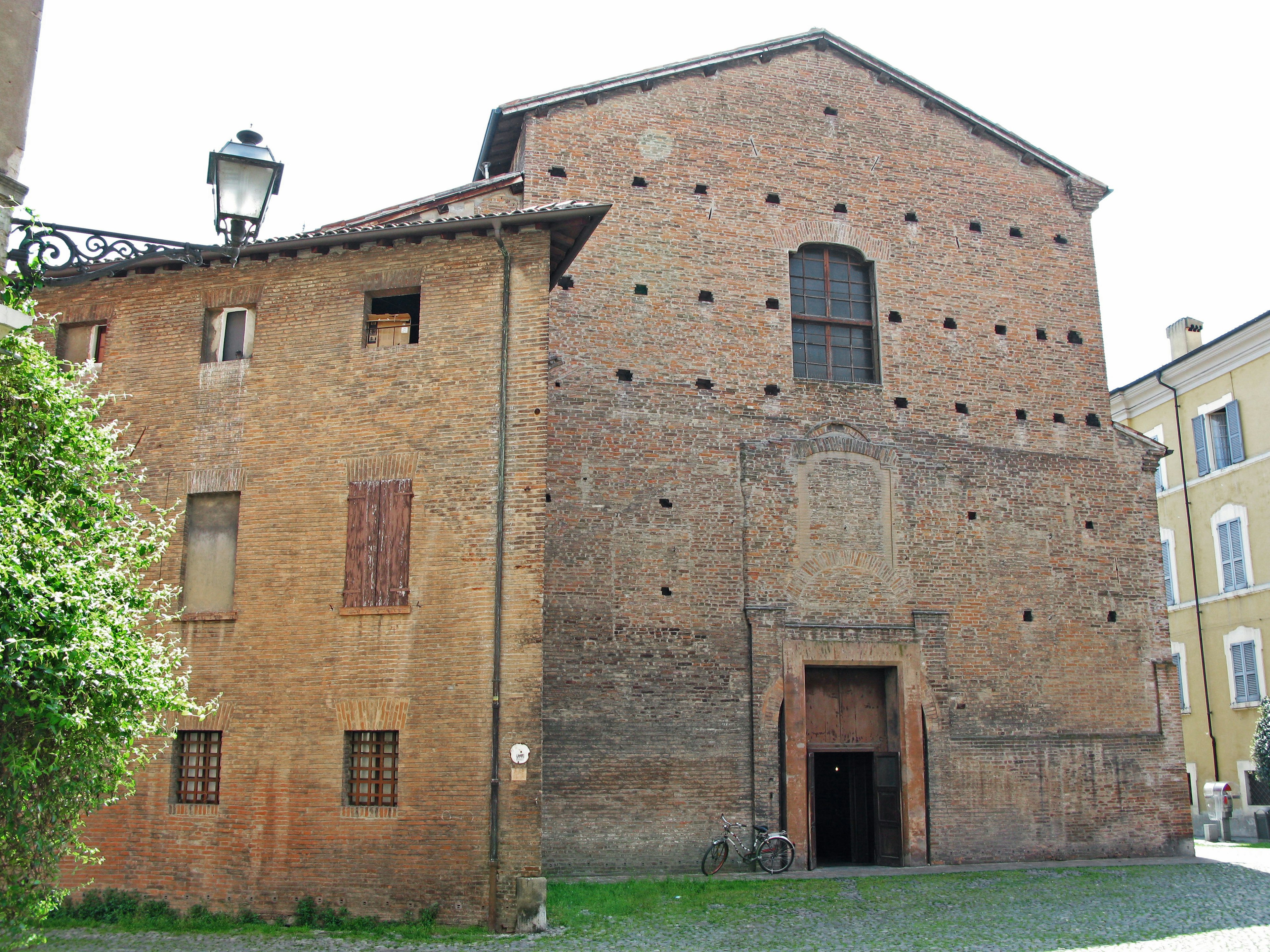 Vue extérieure d'un bâtiment historique en brique avec une porte proéminente