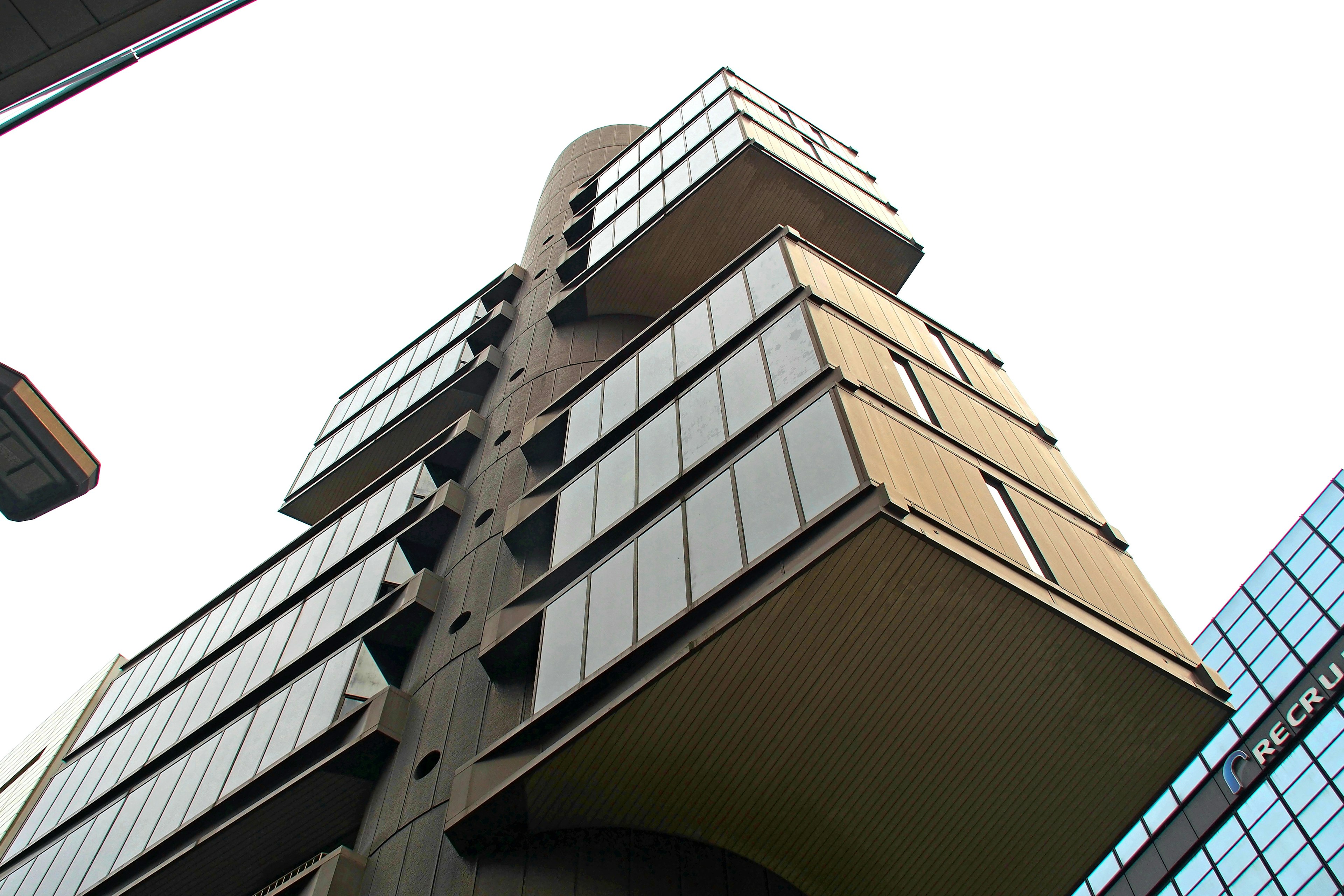 Upward view of a modern building featuring a unique design with glass balconies