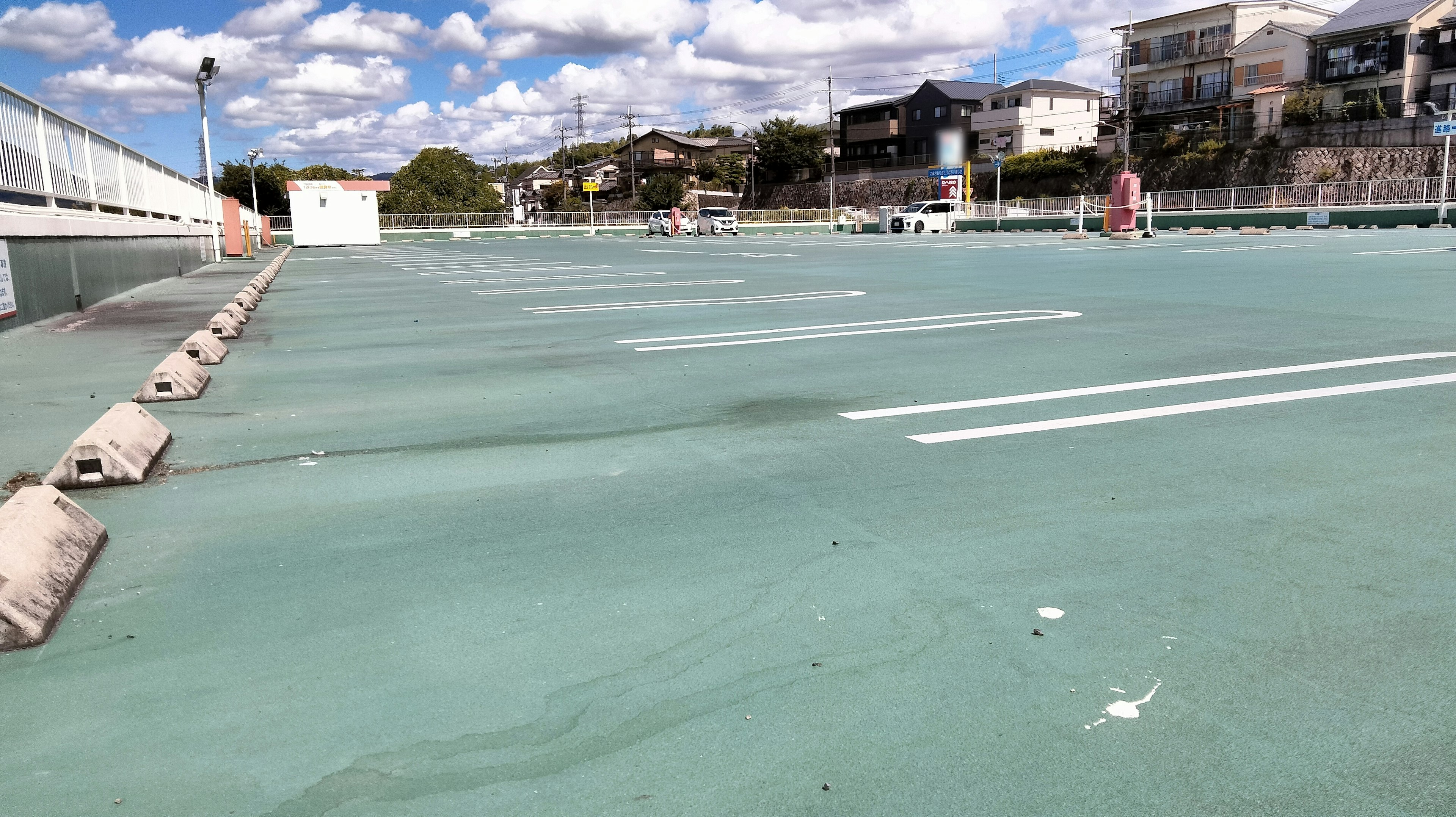 Green parking lot under a blue sky