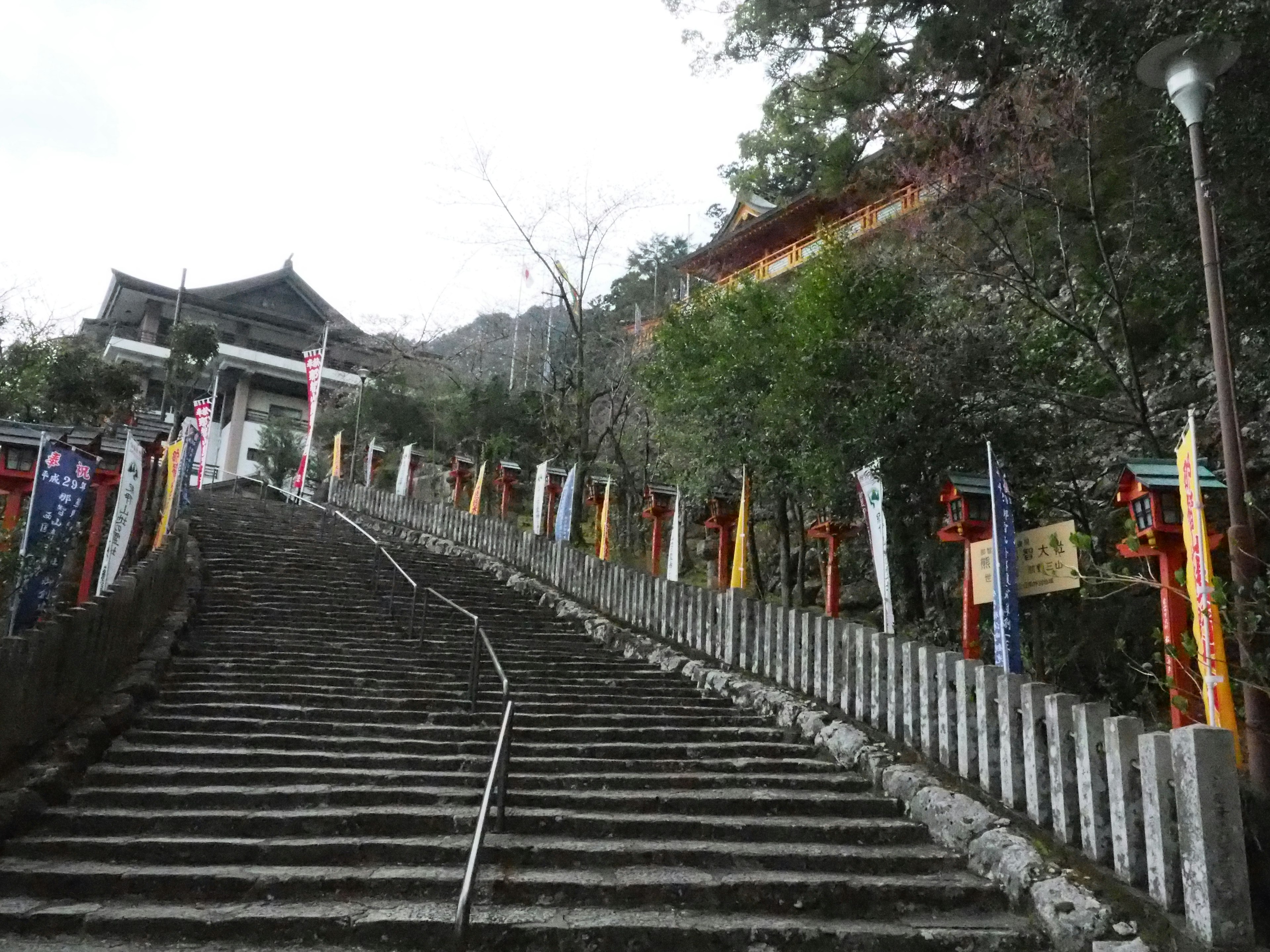 Stairs leading up to a shrine with colorful flags along the path