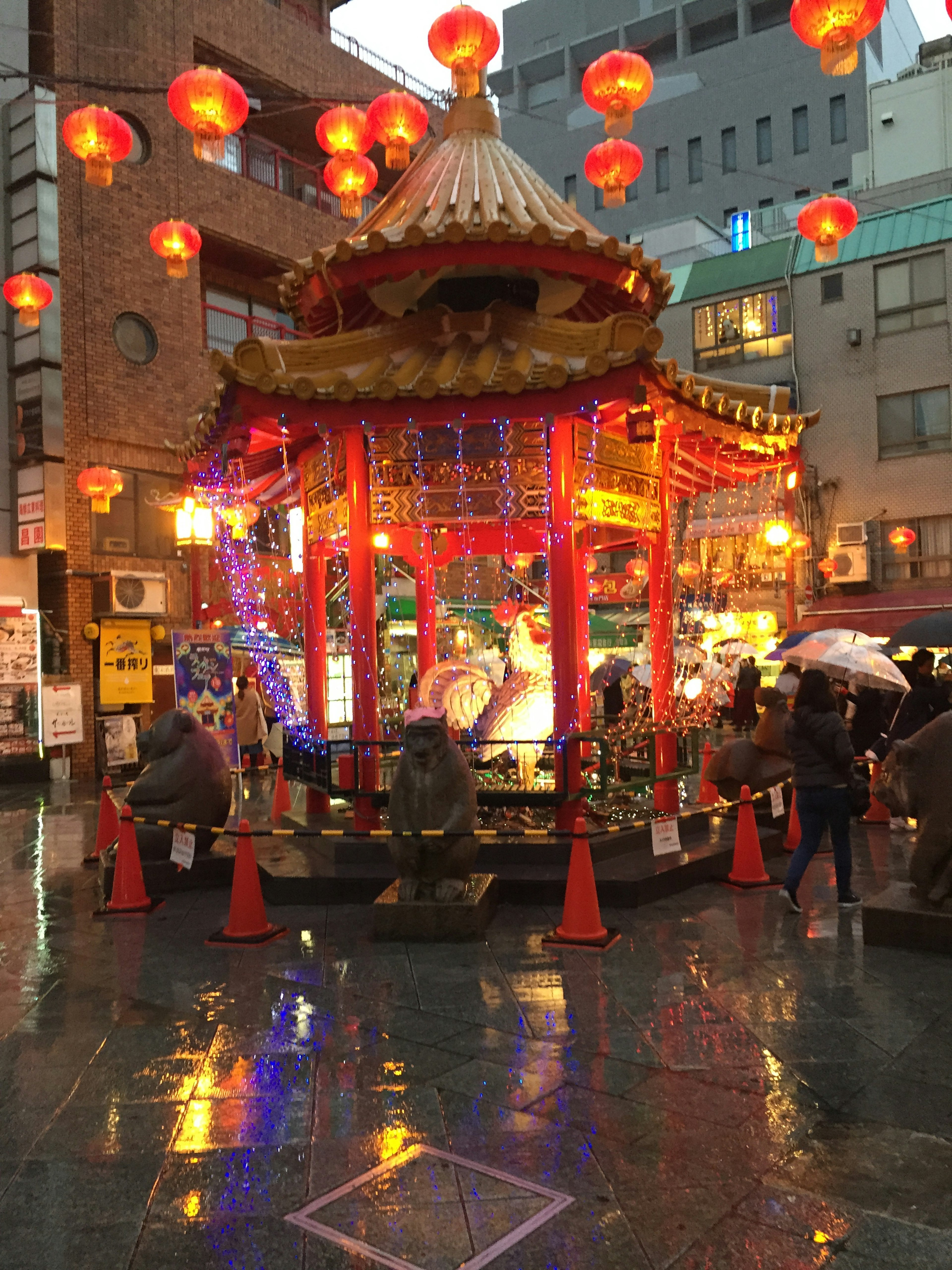 A vibrant pavilion adorned with red lanterns stands in the nighttime street