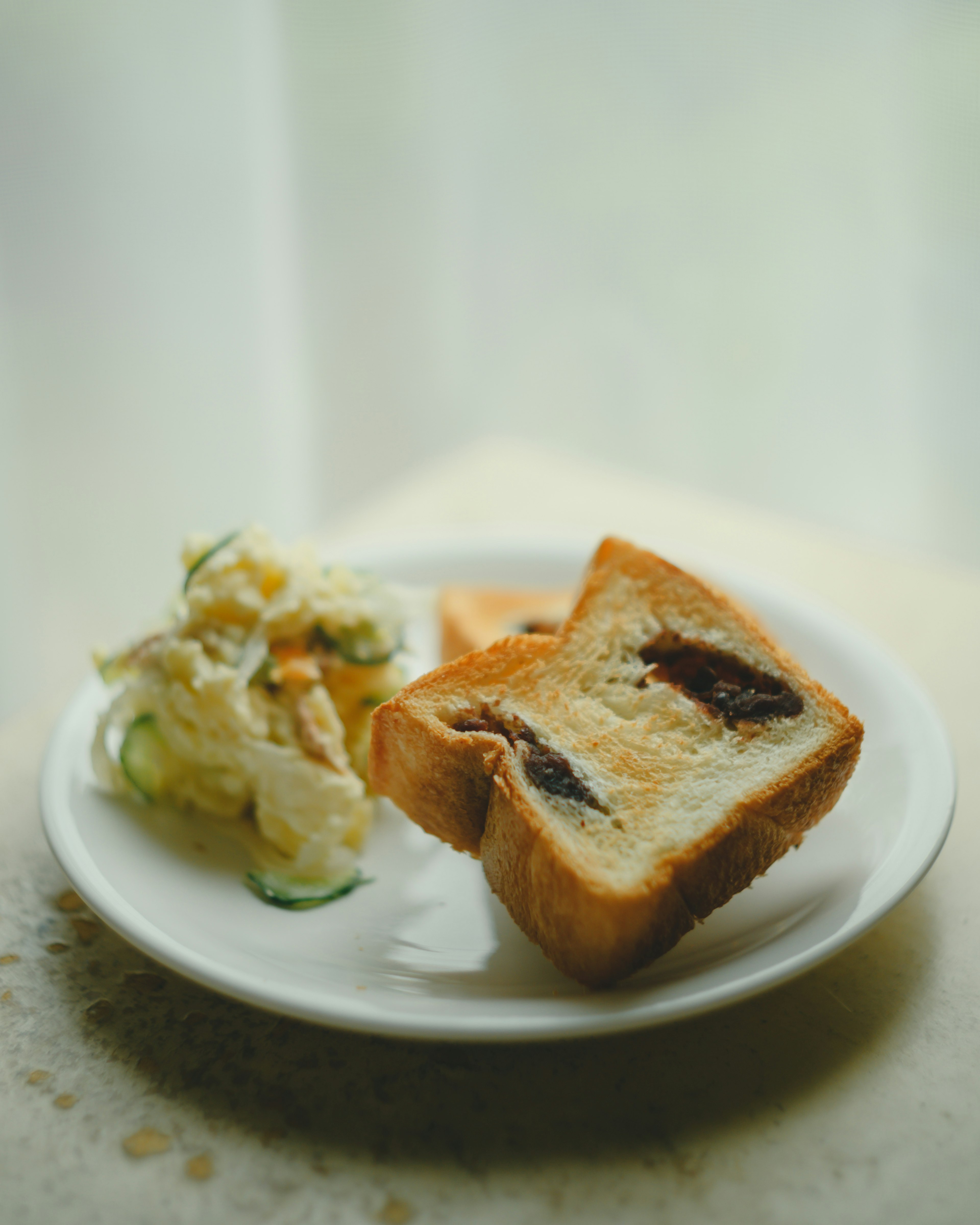 Sliced chocolate cream bread and salad on a white plate