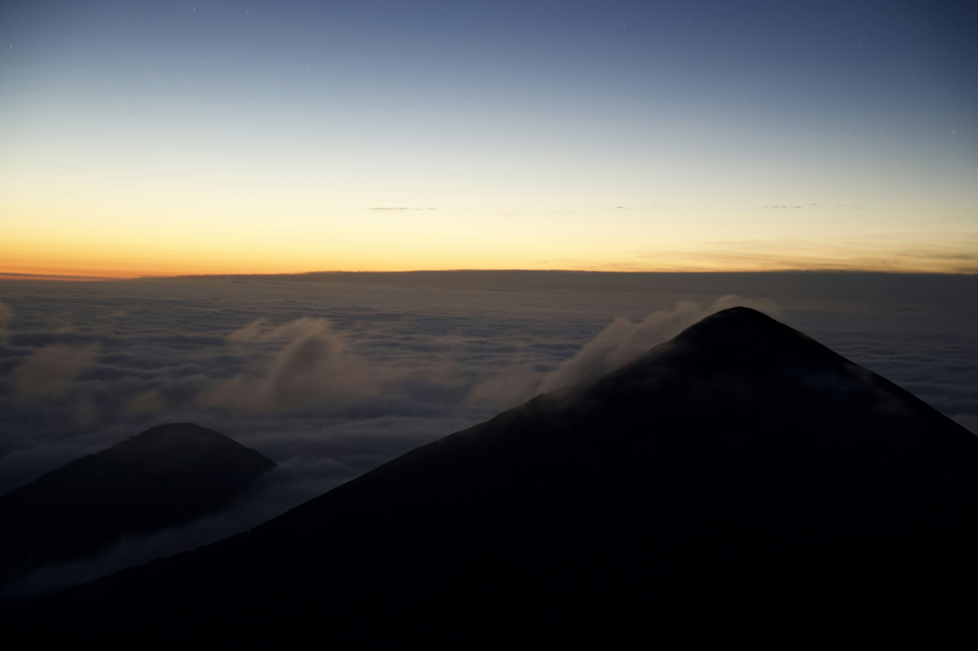 Silhouette di una montagna sopra le nuvole con un bel tramonto