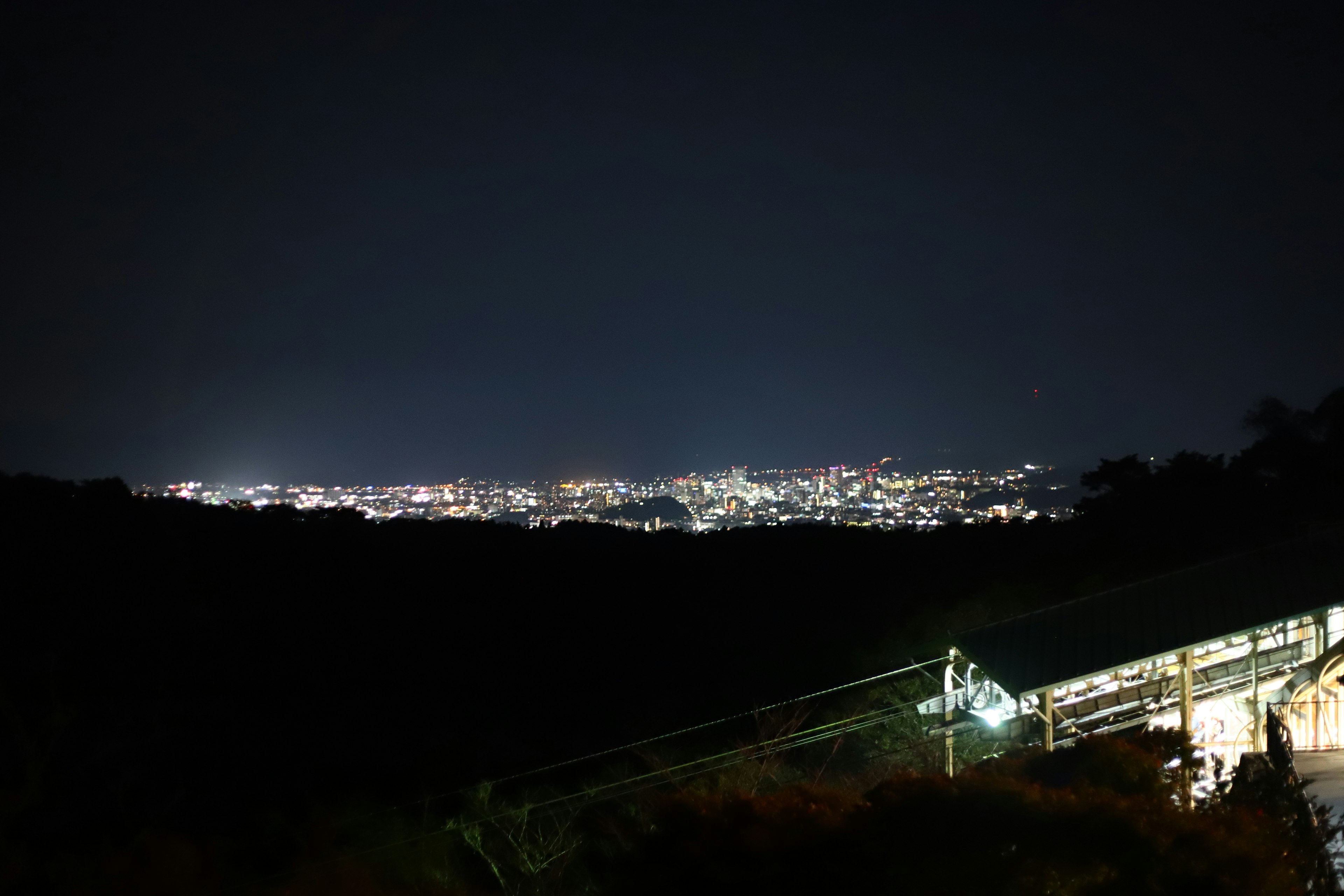 Vista notturna della città illuminata da una montagna