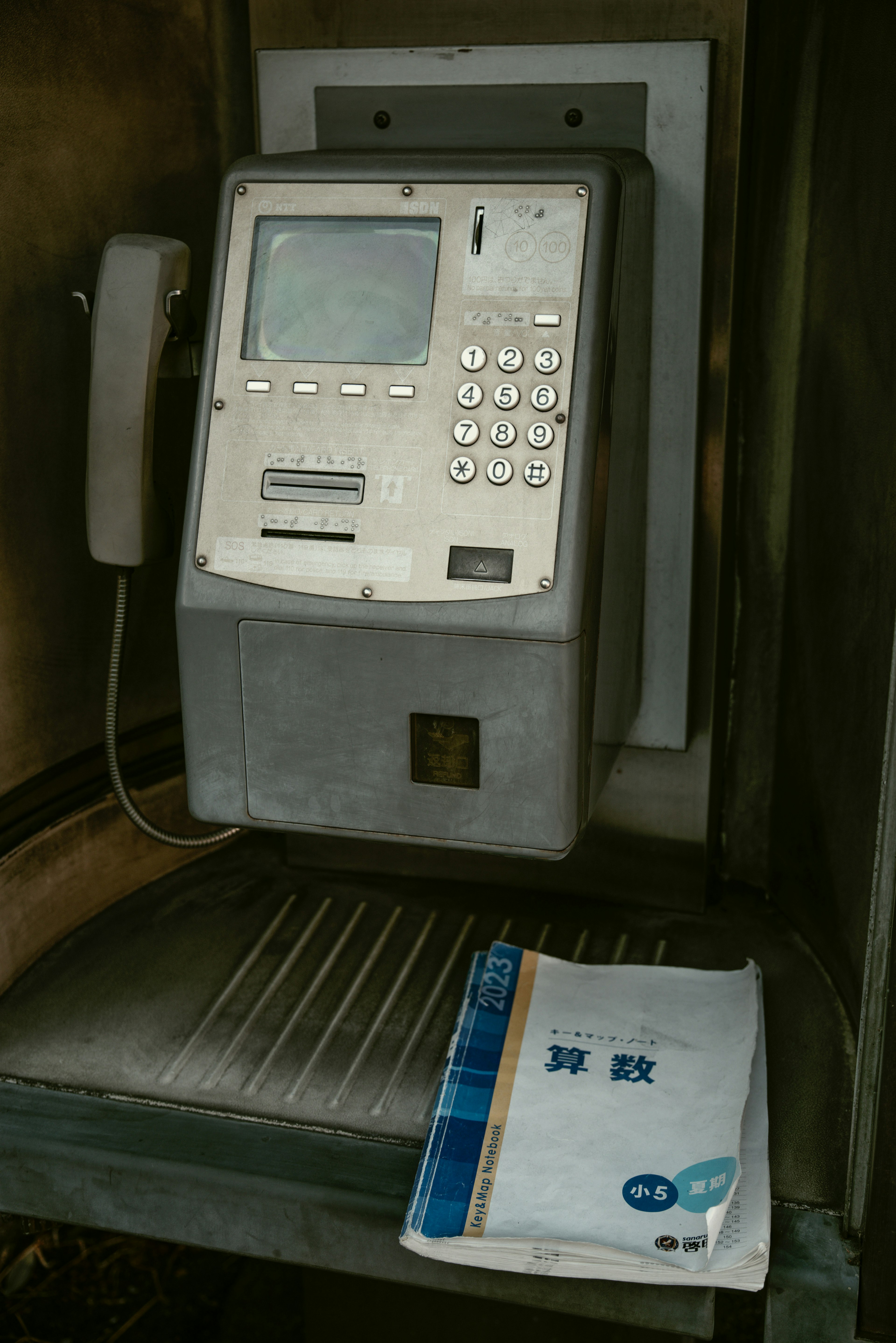 Old public telephone with a user guide nearby