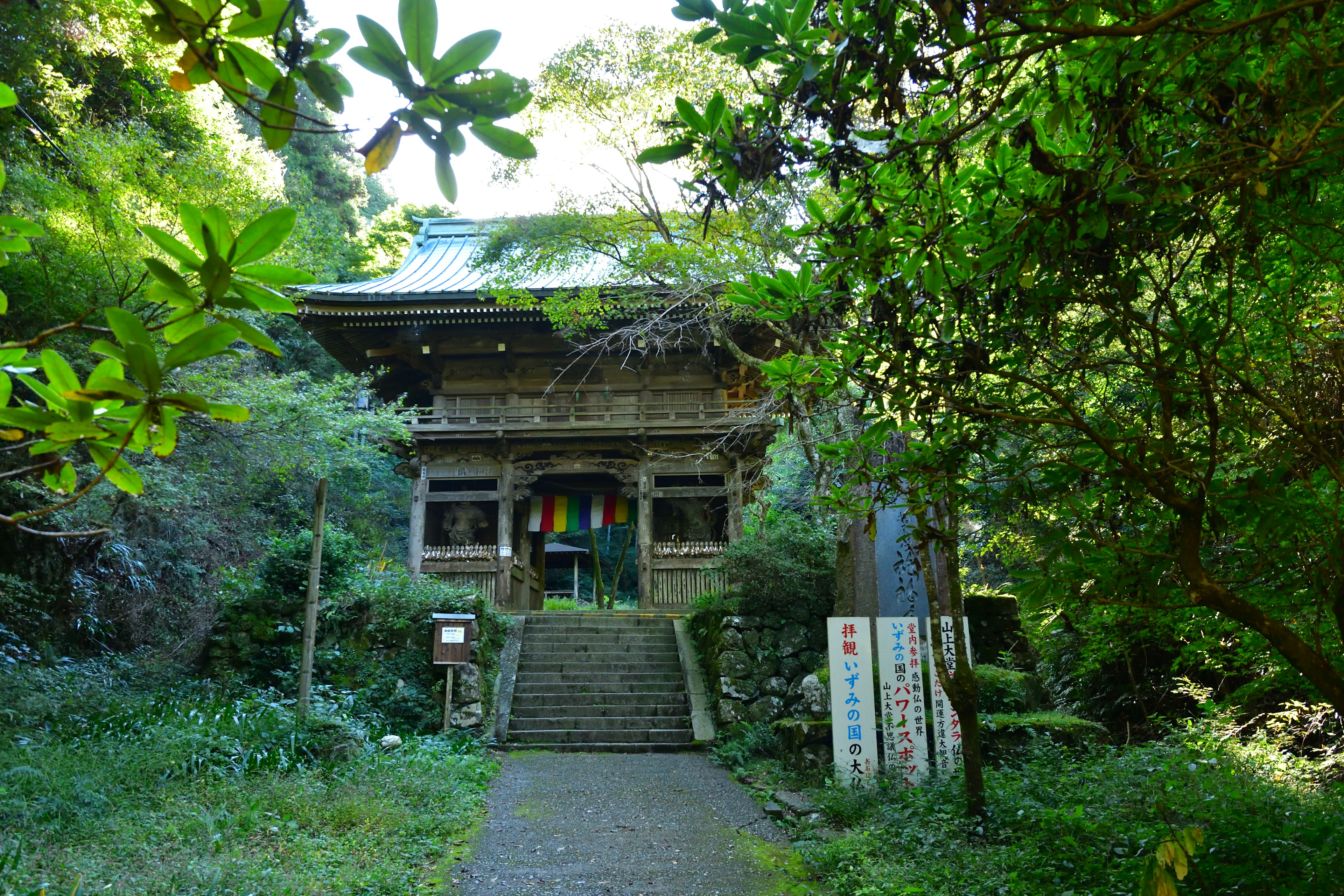 Alter Tempel umgeben von Grün mit Treppen und bunten Stoffen