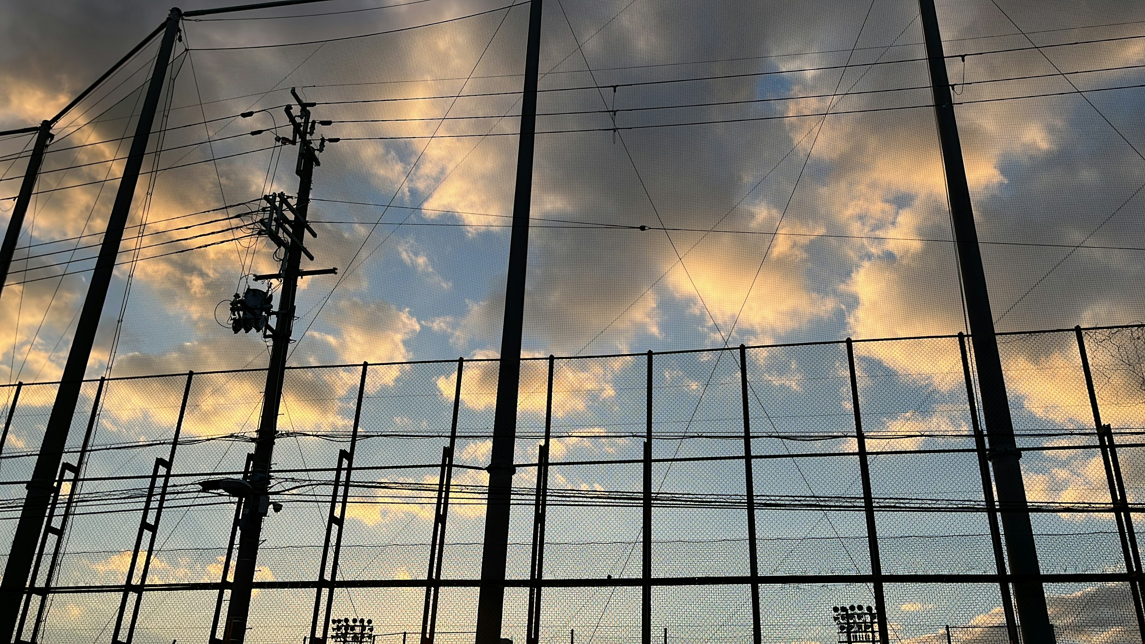 Vista del cielo vespertino con nubes y una red deportiva