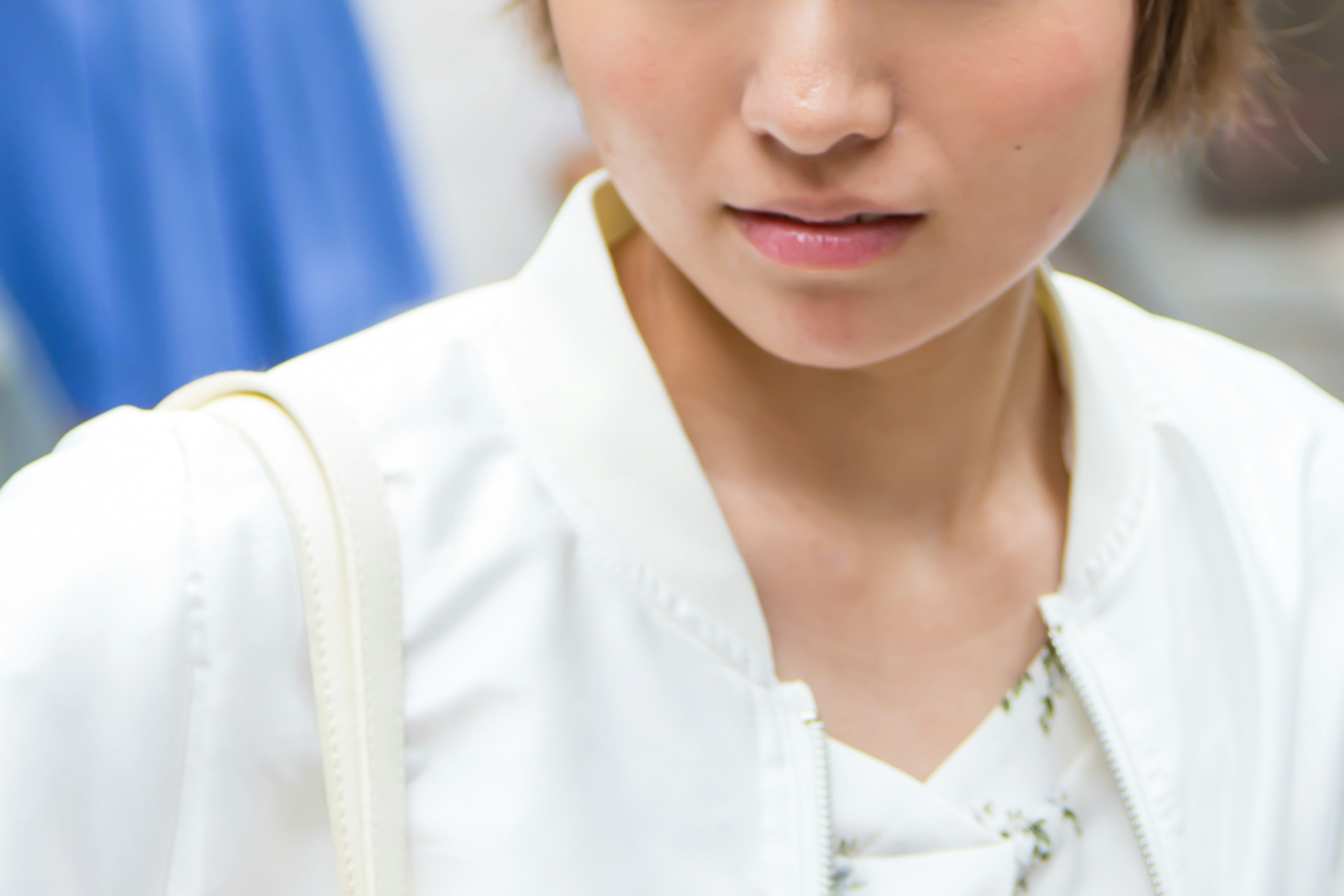 Jeune femme portant une veste blanche avec une expression sérieuse