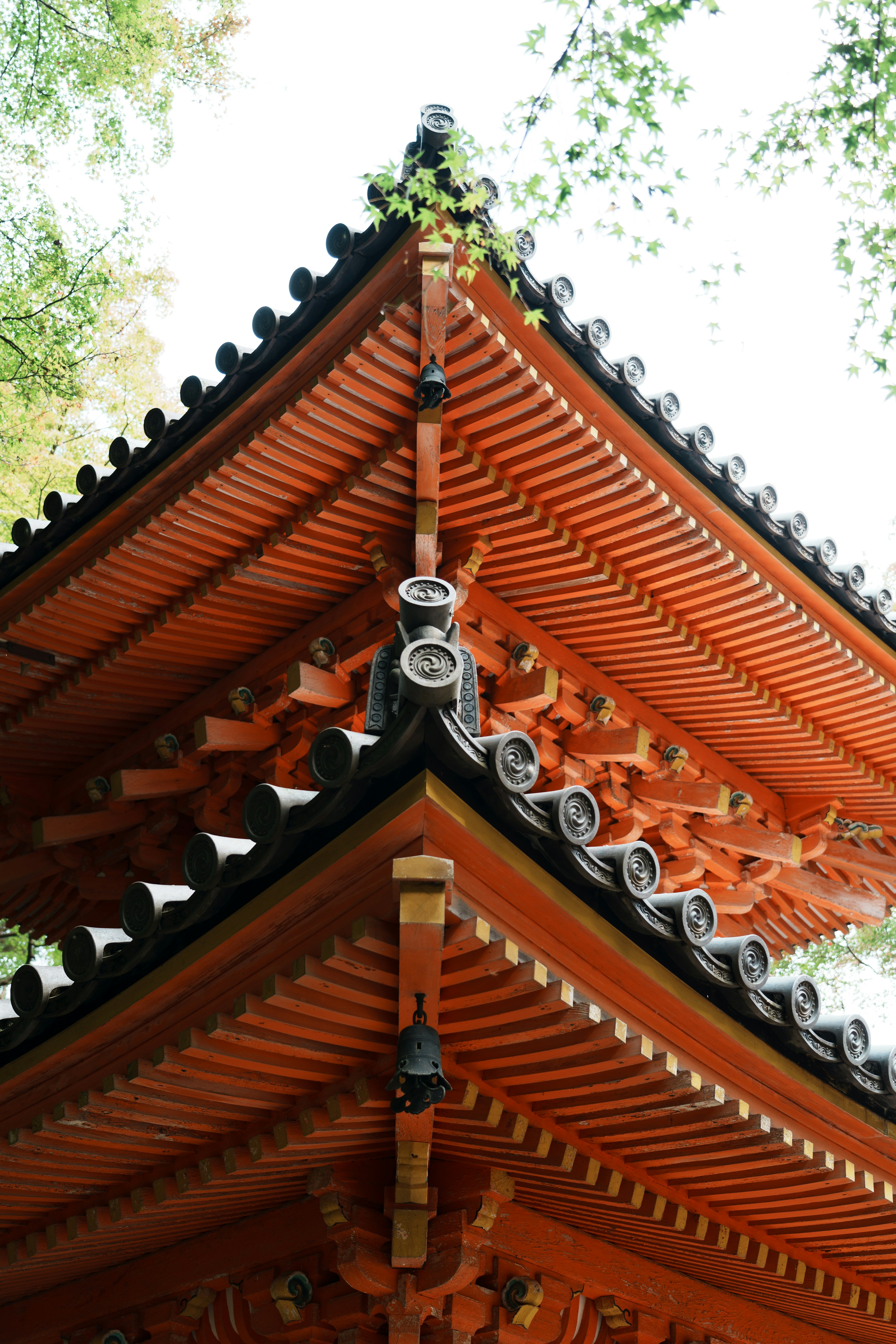 Detail eines traditionellen Tempeldachs mit lebendiger roter Farbe und komplexer Holzarchitektur