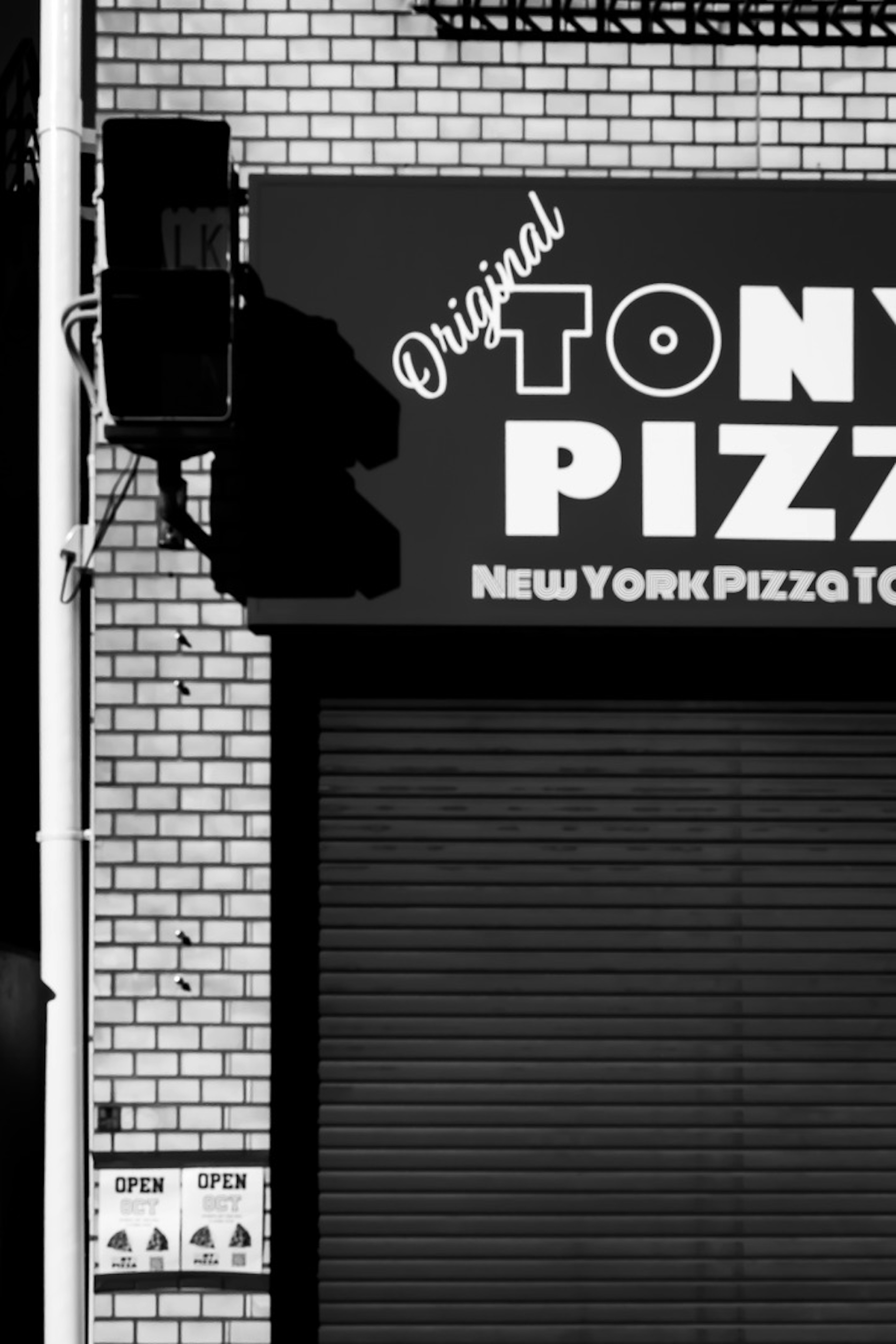 Fachada exterior en blanco y negro de la pizzería Tony