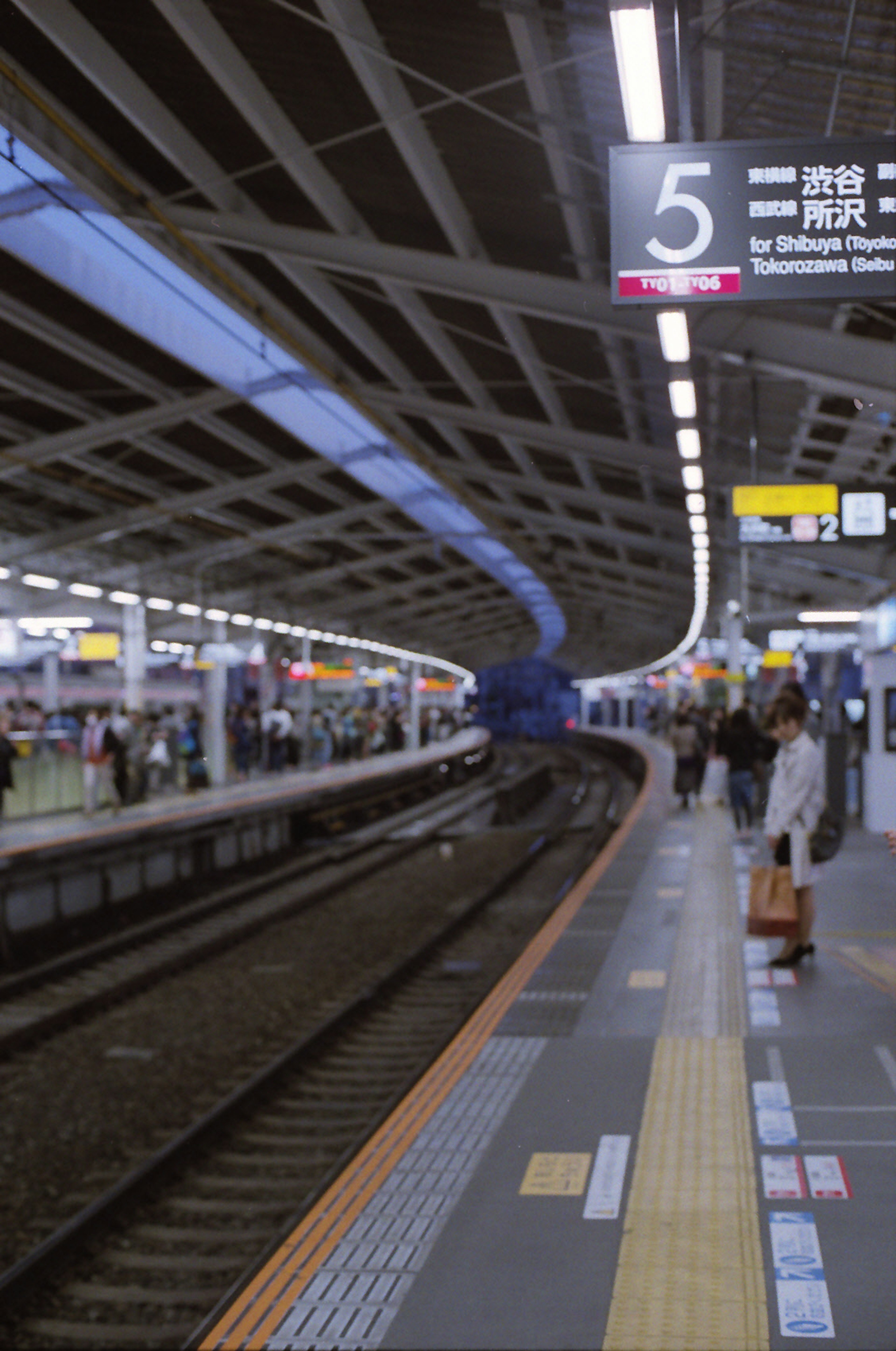 A view of a train platform with people and a curved structure