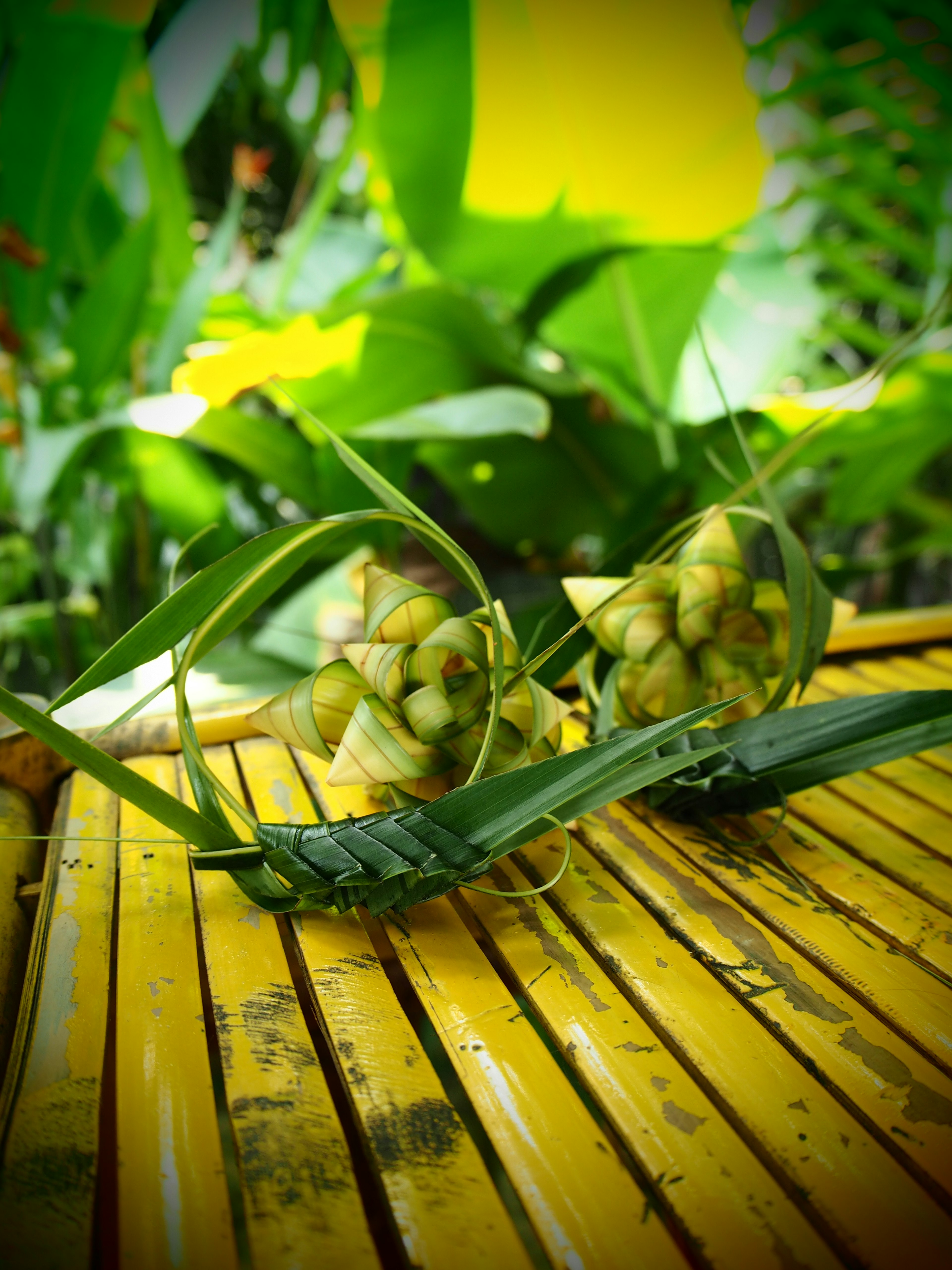 Buah mirip nanas diletakkan di permukaan bergaris kuning dikelilingi daun hijau