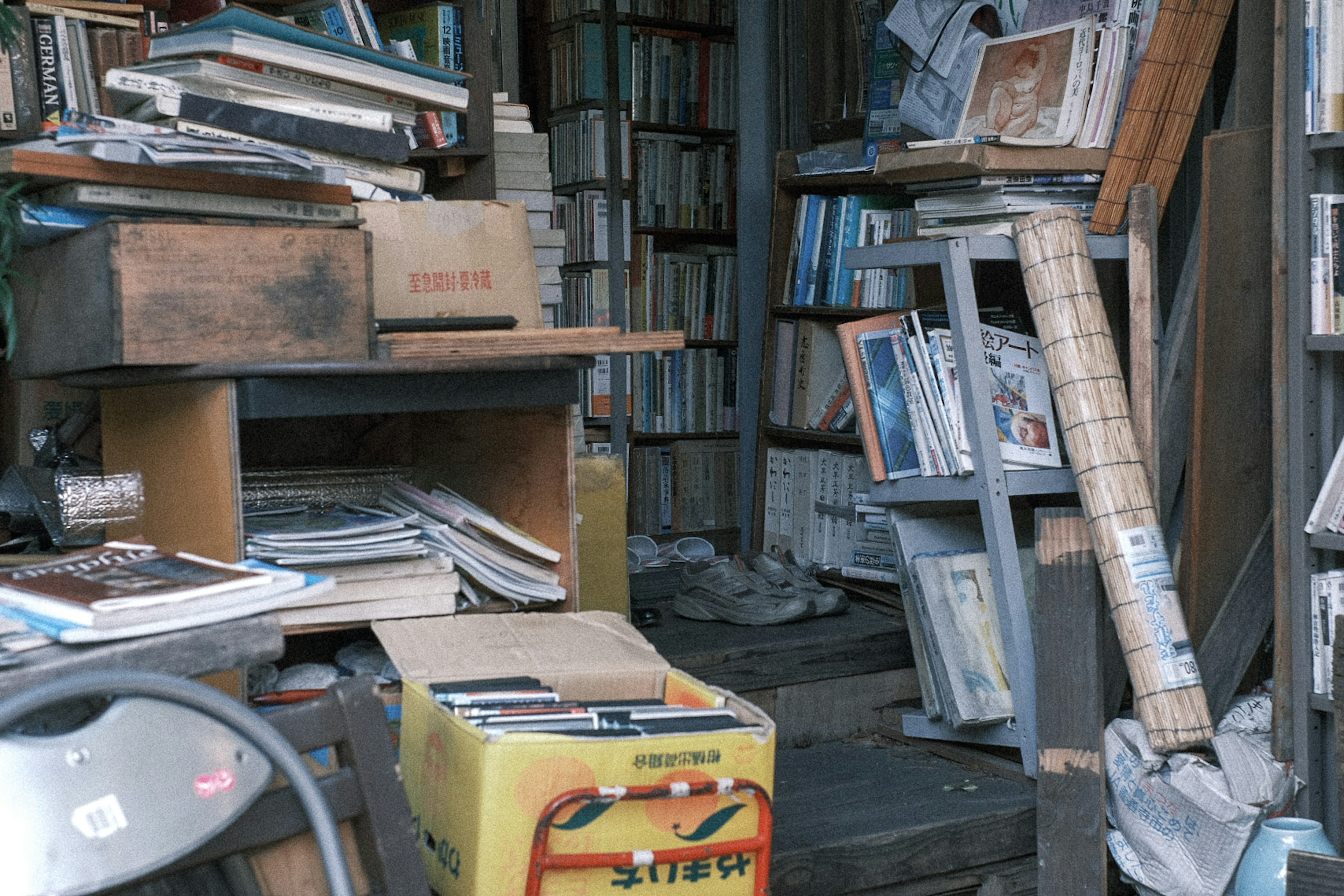 Unordentliches Zimmer voller verstreuter Bücher und verschiedener Gegenstände