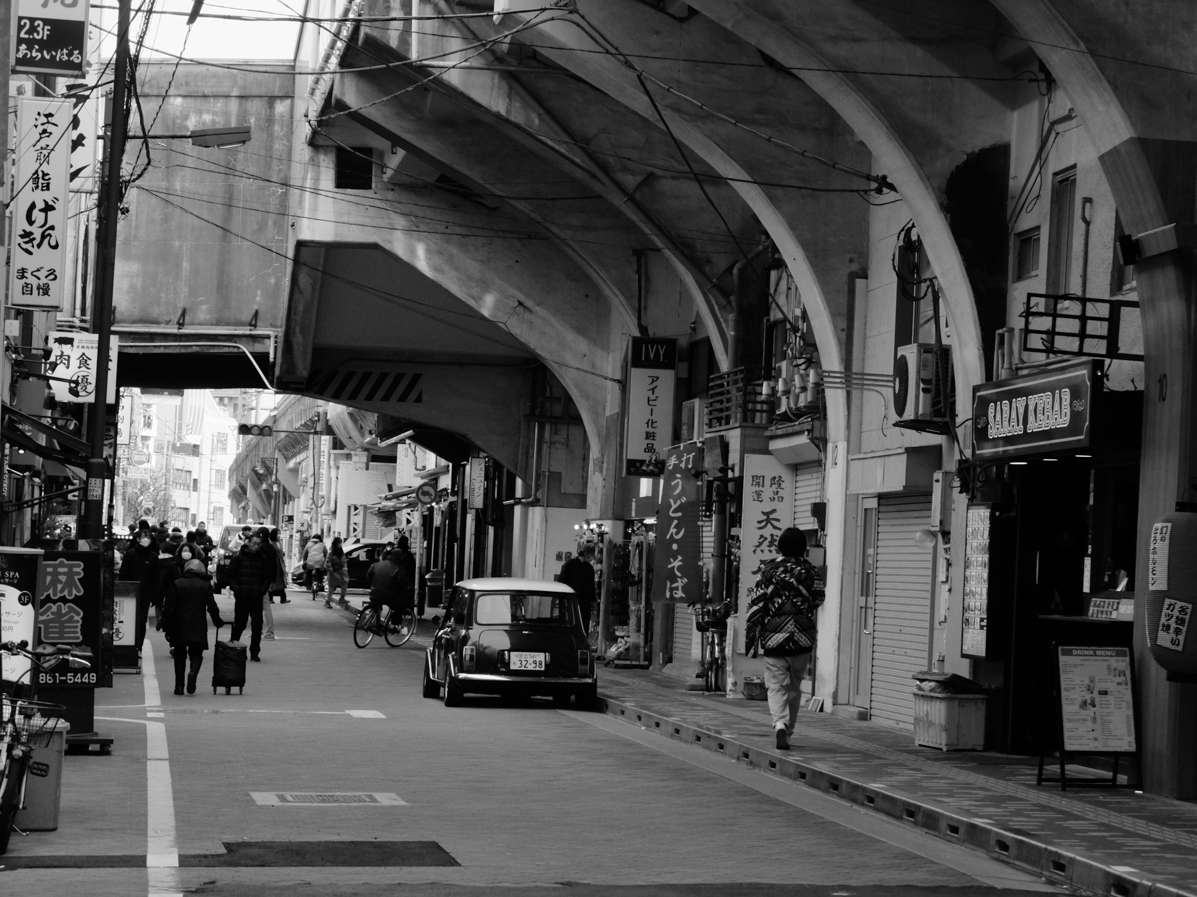 Black and white street scene featuring arcade architecture