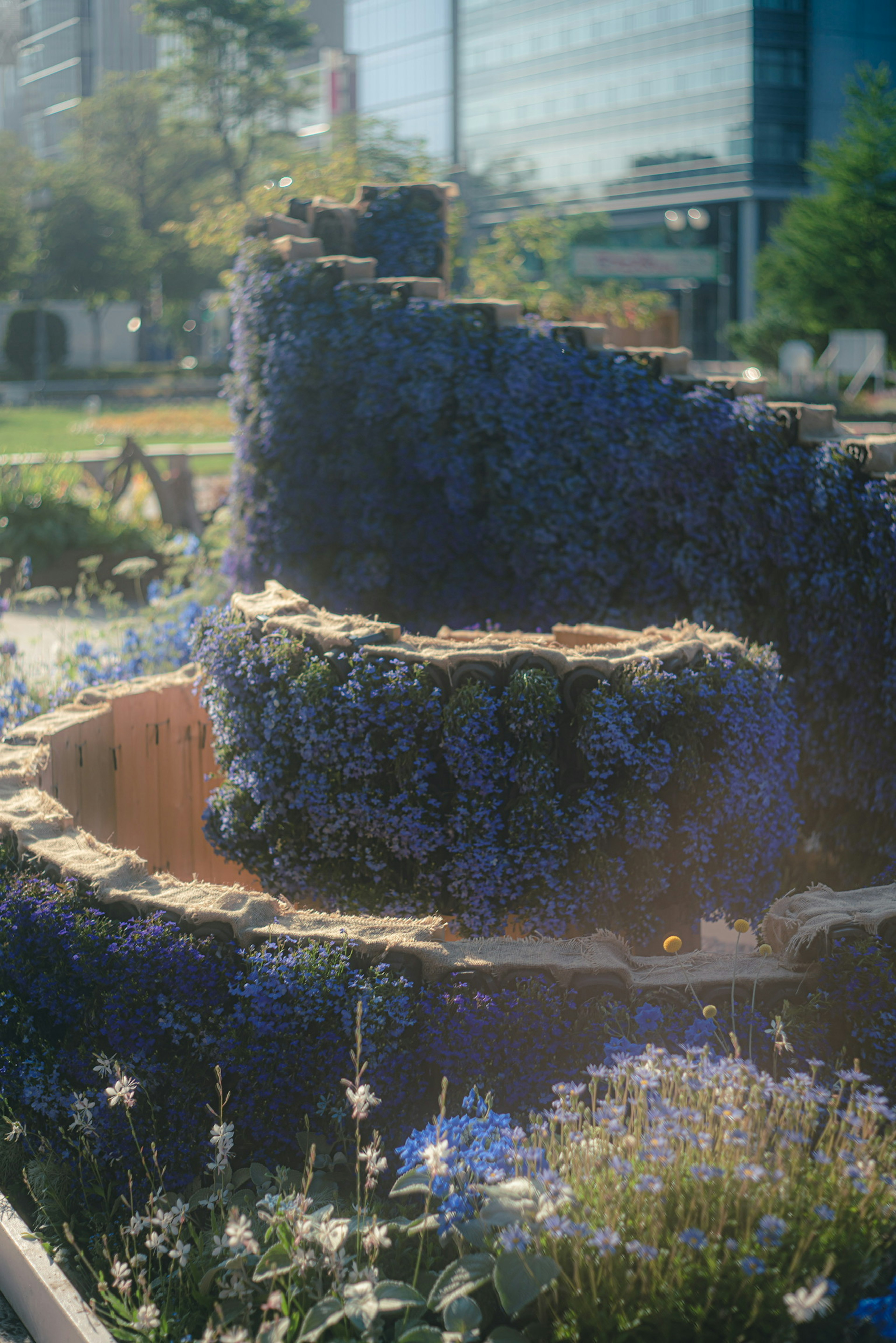 Scène de parc avec un mur courbé recouvert de fleurs bleues