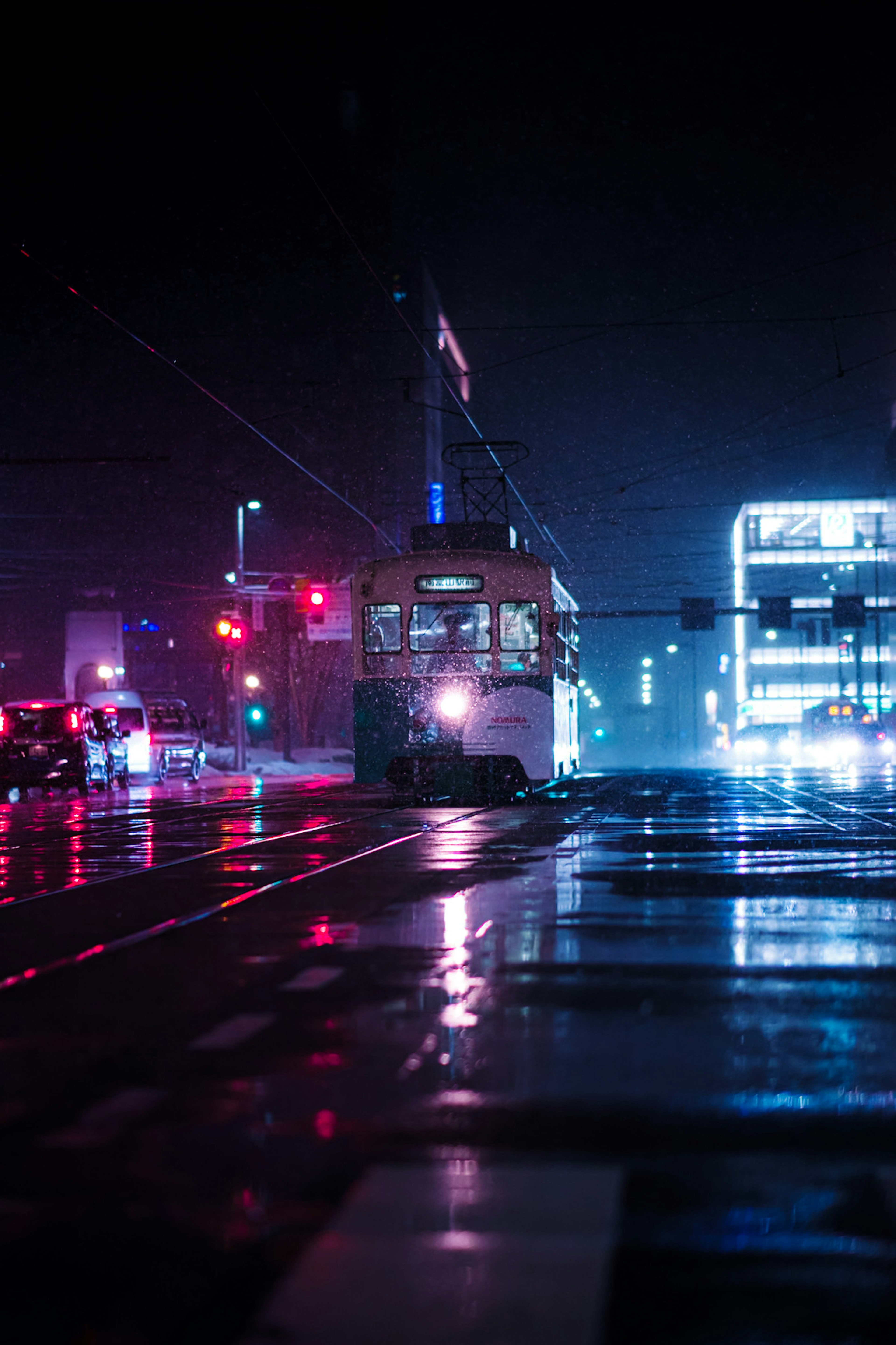 Tram in the city at night with reflections on wet streets