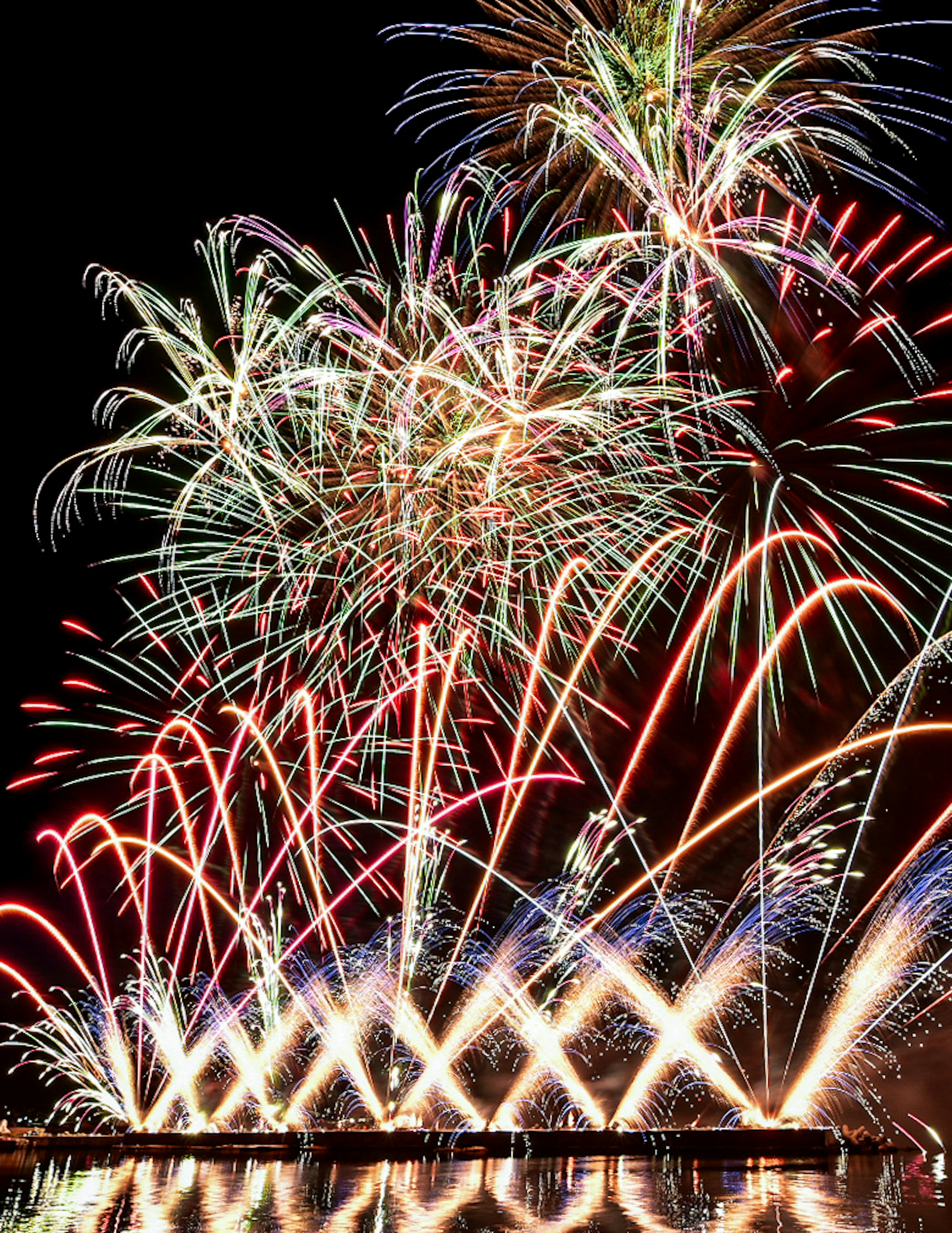 夜空に輝く色とりどりの花火が打ち上げられるシーン