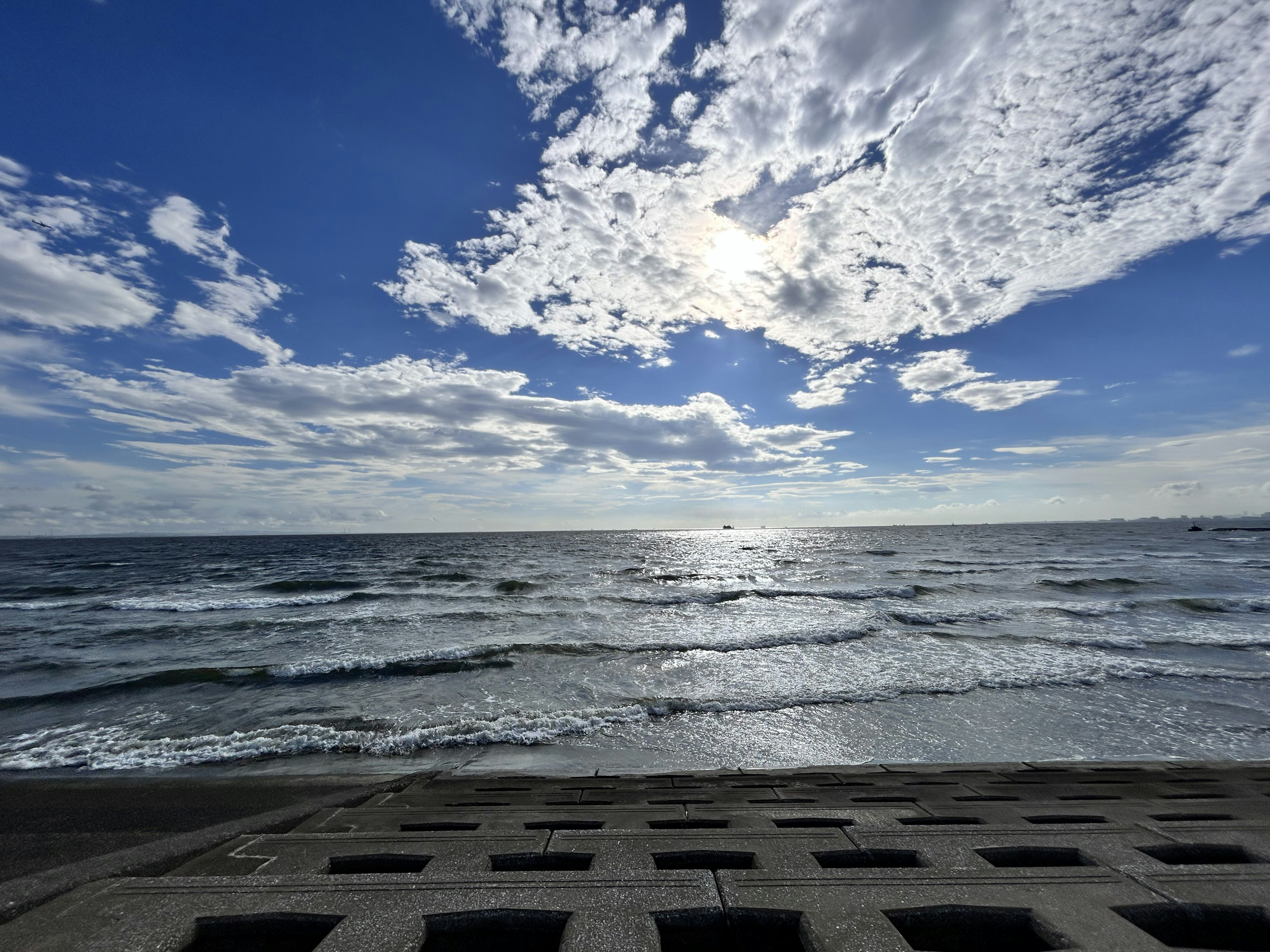 Schöne Küstenansicht mit blauem Himmel und weißen Wolken Wellen sanft schlagen