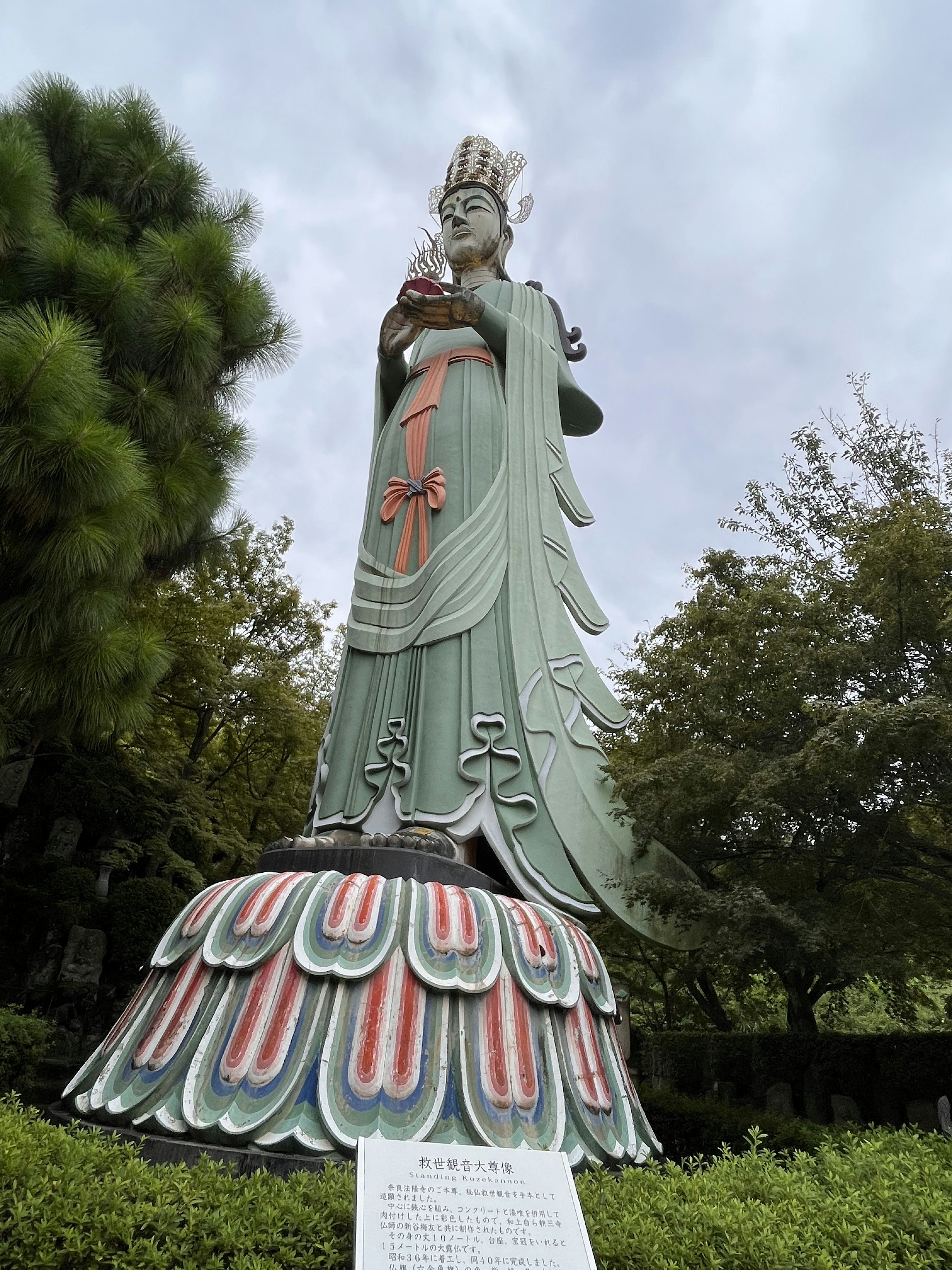 Patung Guanyin tinggi dikelilingi pohon hijau