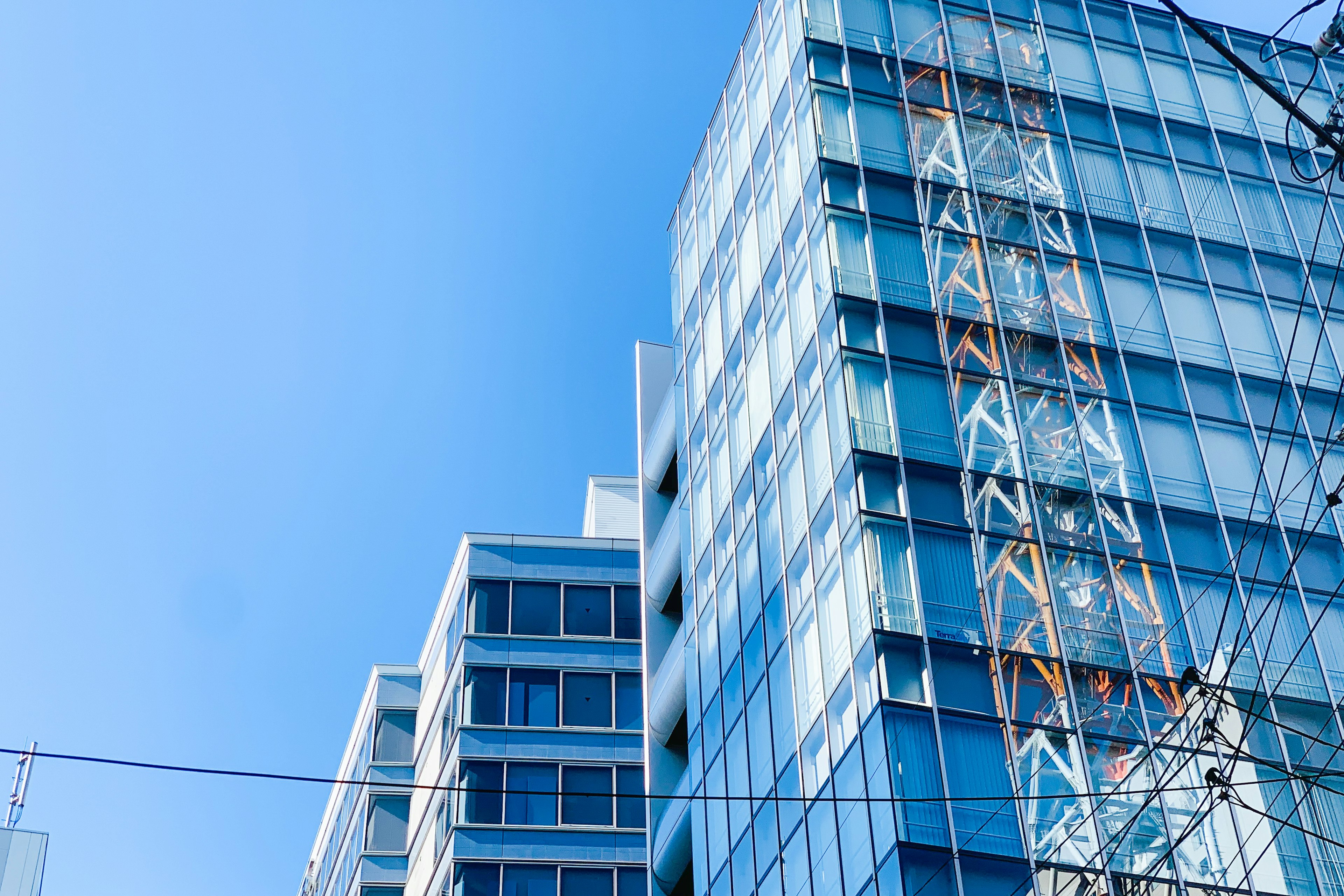 Modern buildings under a blue sky featuring glass facades and steel structures