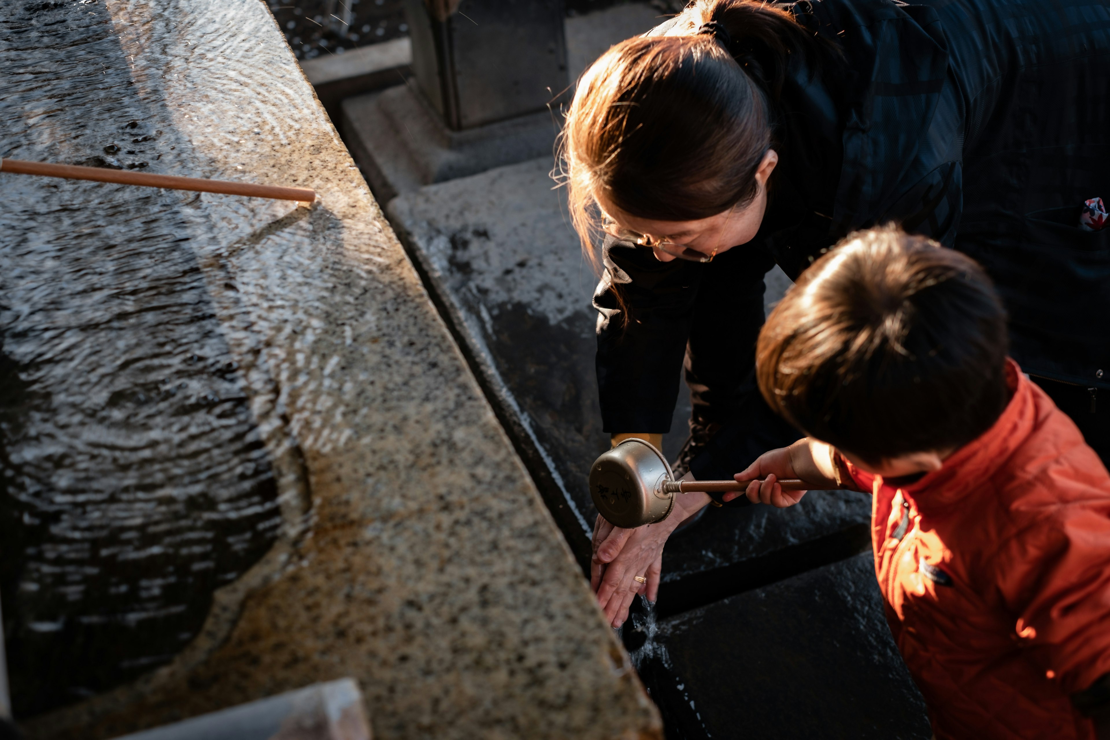 A mother and child washing hands with water