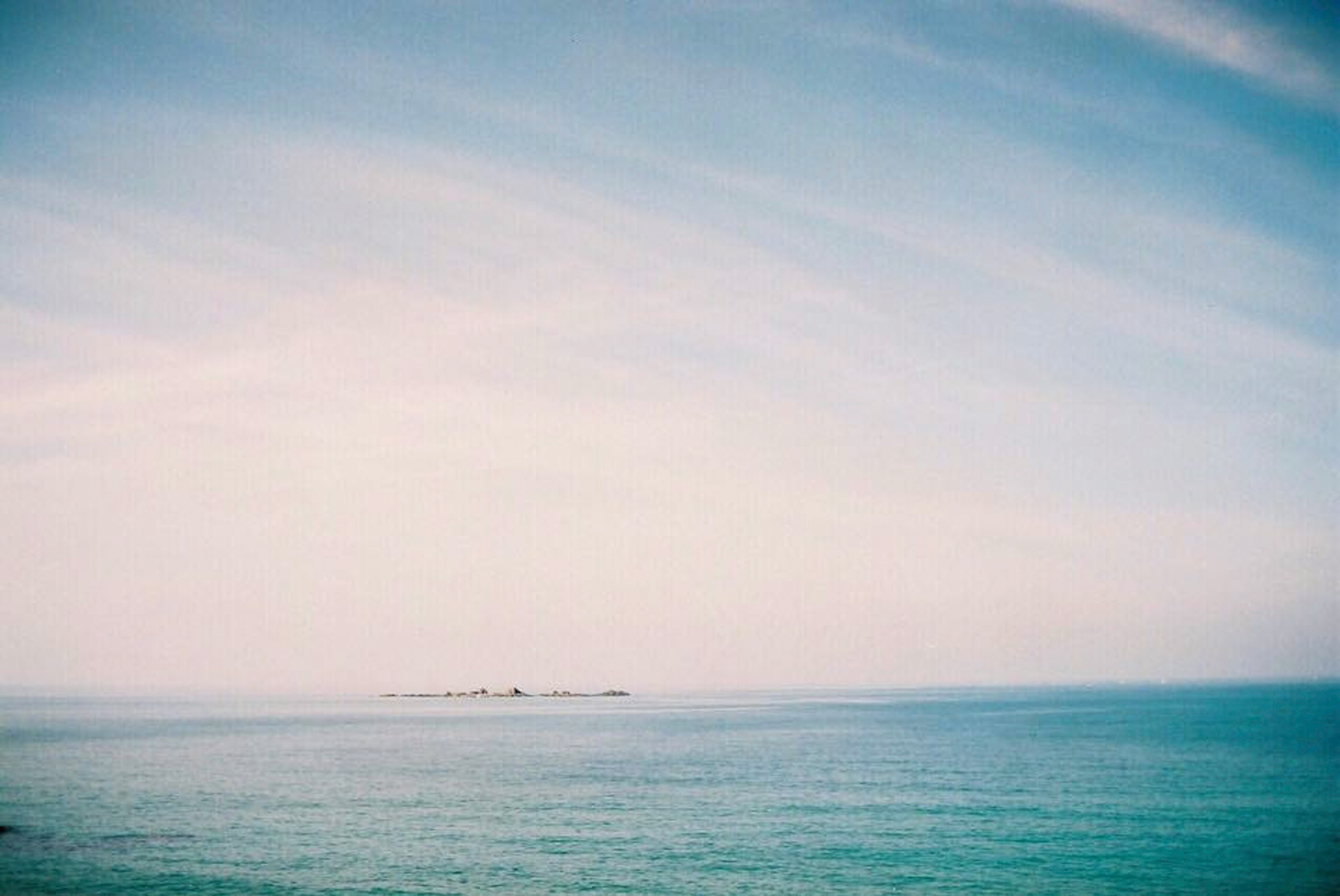 Vue sereine de la mer et du ciel bleu avec une île au loin