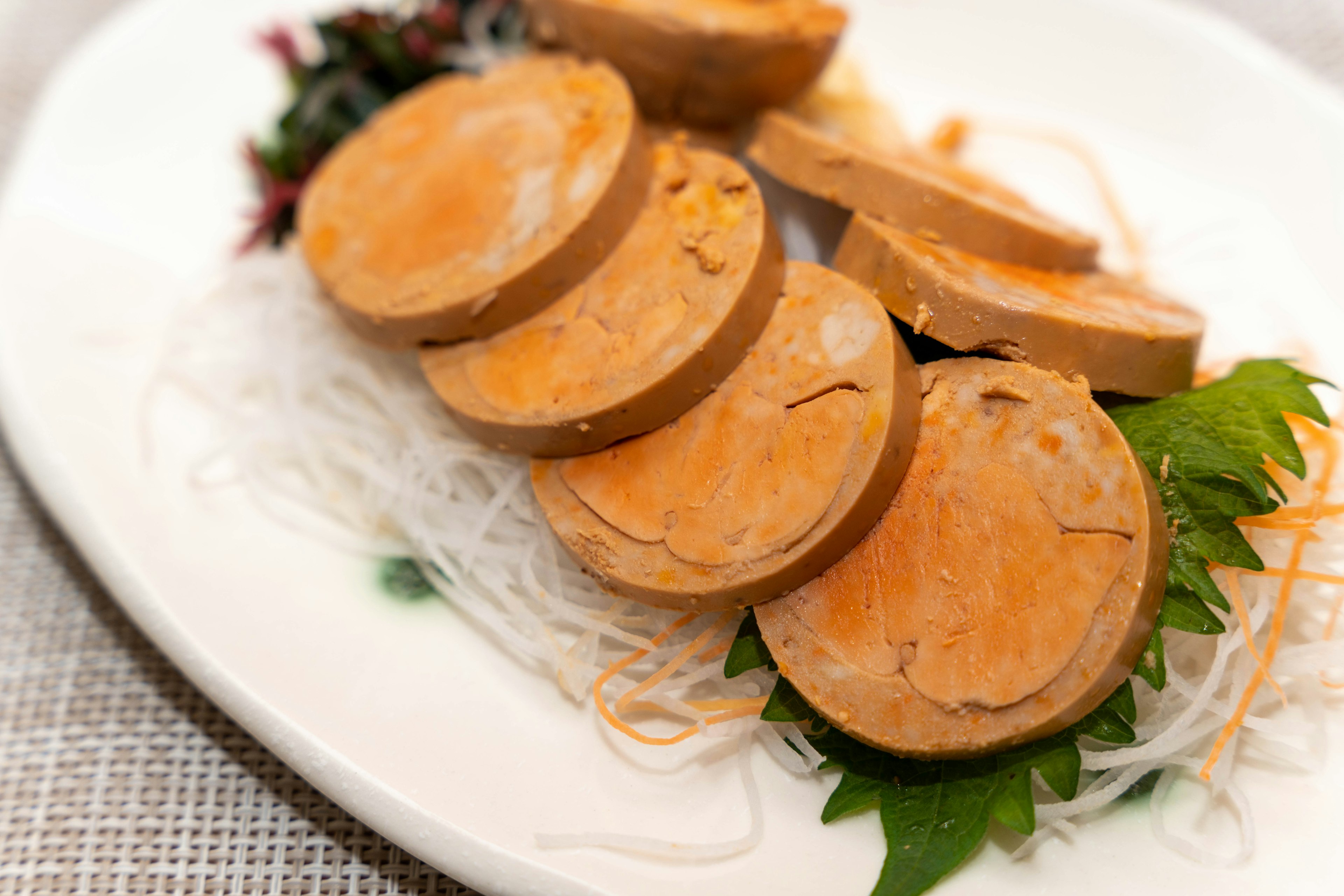 Sliced orange dish presented on a white plate with garnishes