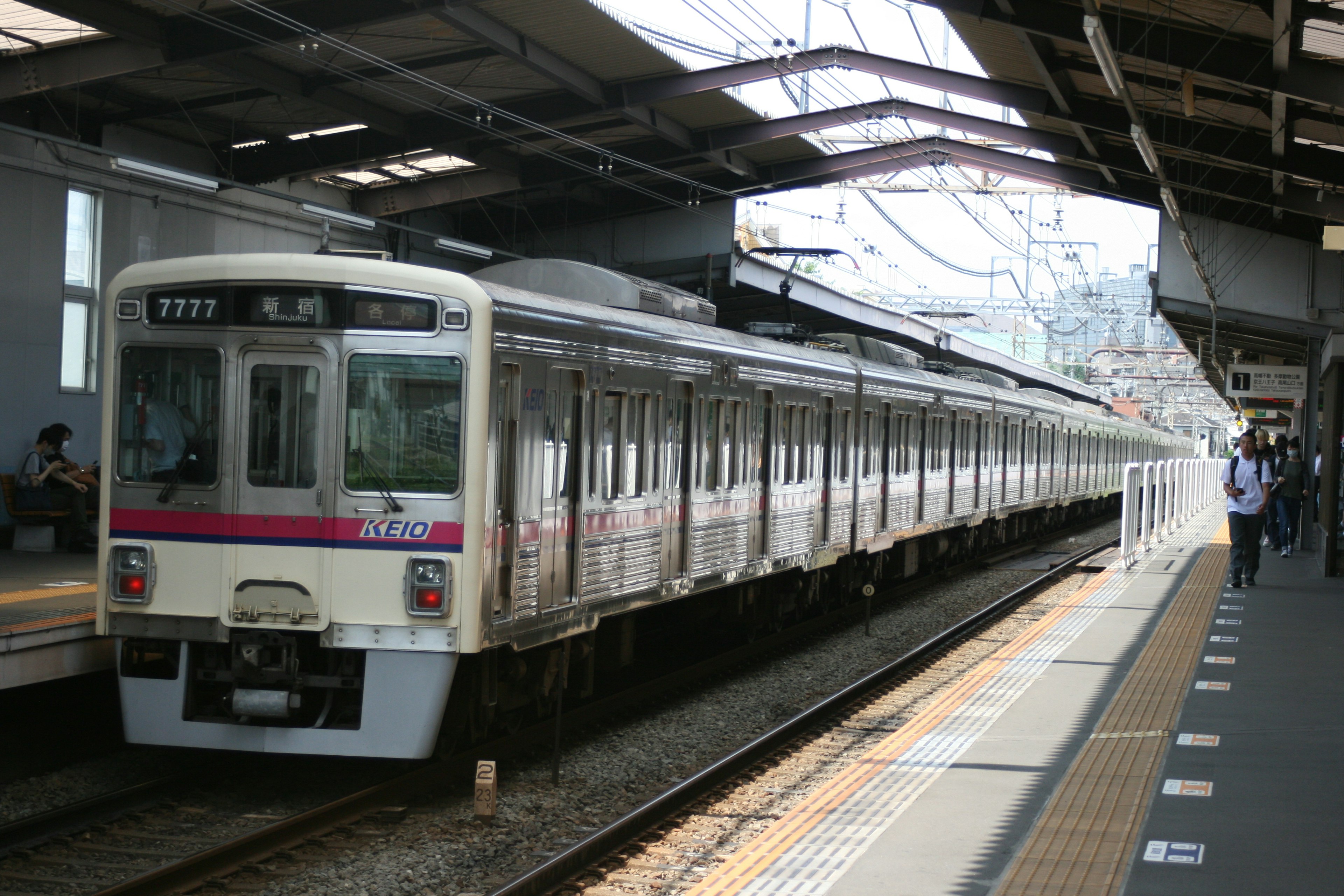 รถไฟที่สถานีกับผู้โดยสารและชานชาลา